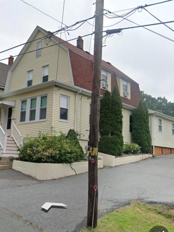 A house with a telephone pole in front of it