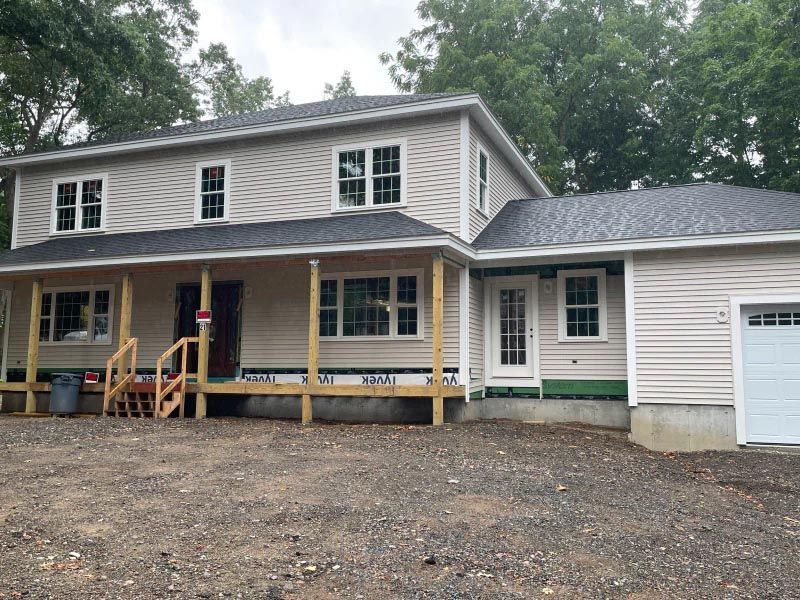 A house with a porch and a garage under construction