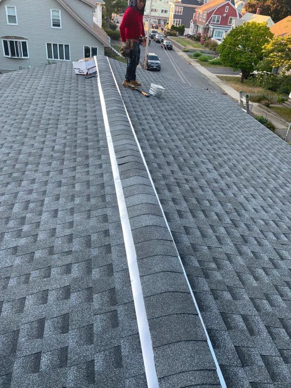 A man is standing on the roof of a house.
