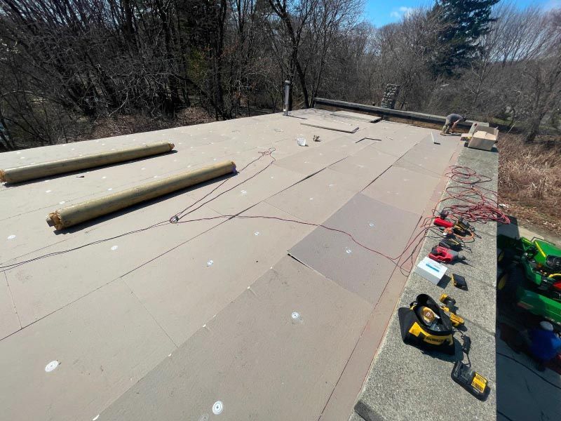 A roof with a lot of tools on it and trees in the background.