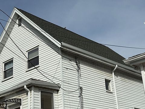 A white house with a black roof and windows