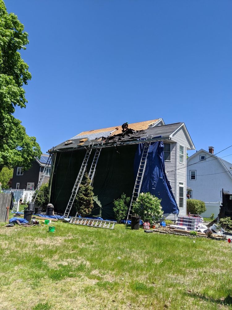 A house with a tarp on the roof is being remodeled.