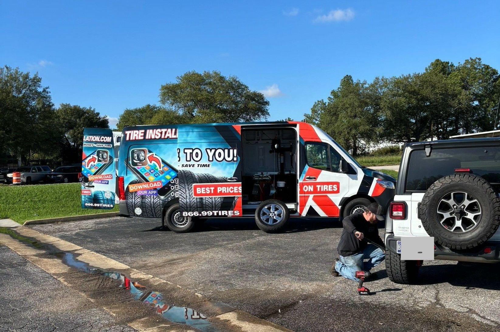 A tire installation van is parked in front of a building