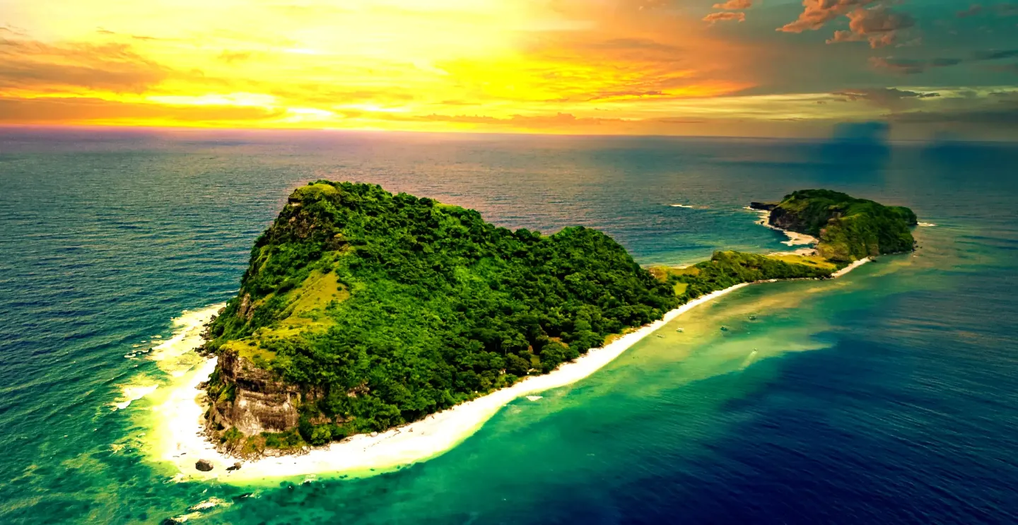 Green islands with dense foliage, white beaches, and turquoise water under a sunset sky.