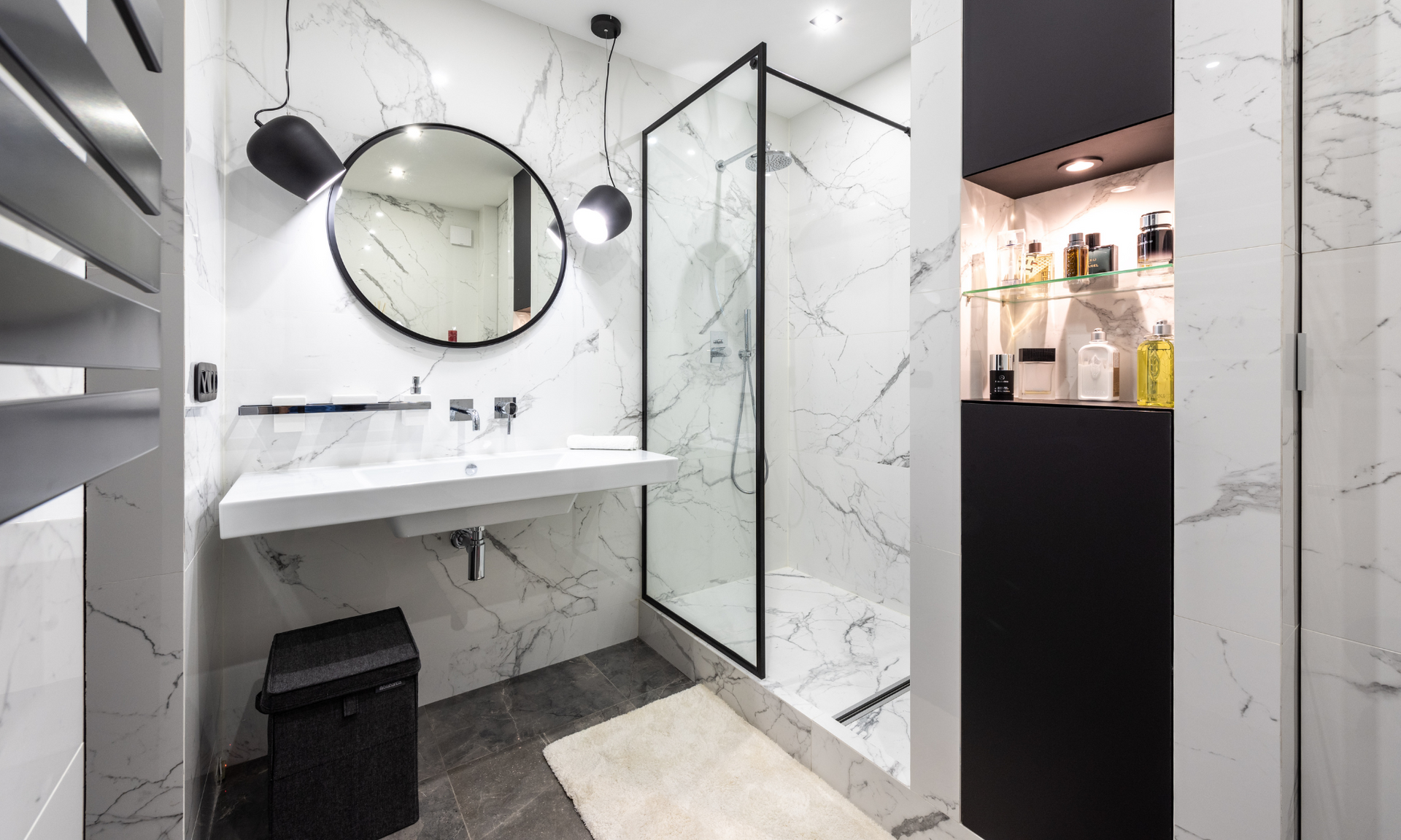 Een badkamer met wastafel, spiegel en inloopdouche.