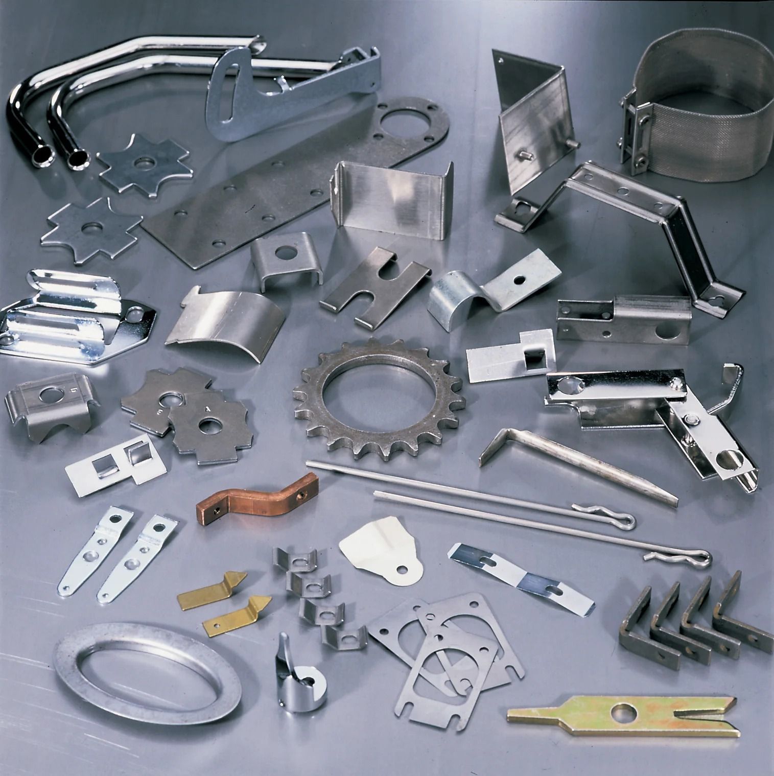 Metal stamped parts in various shapes and sizes, including brackets, gears, and rings.