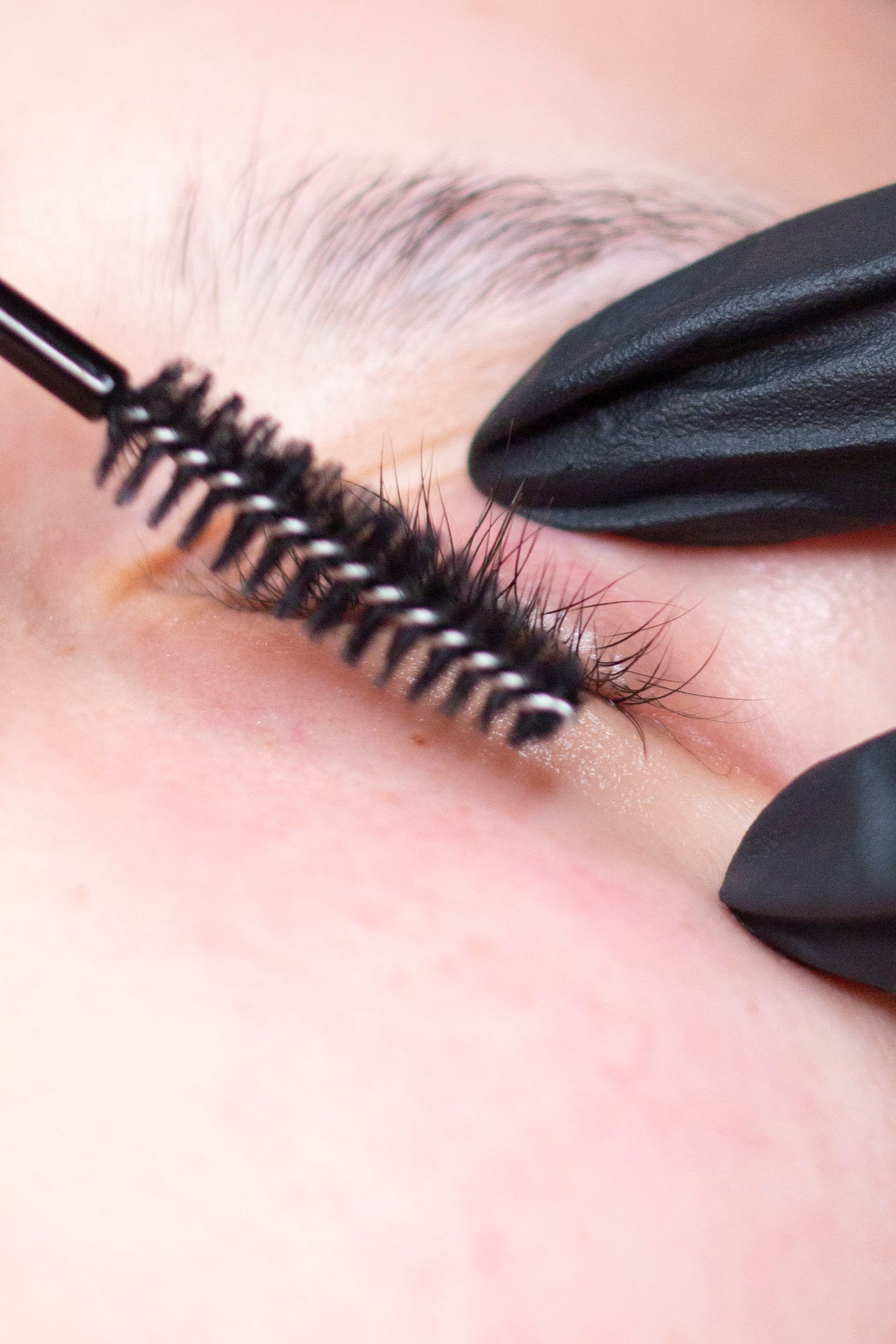 Primo piano di una persona che si applica il mascara sulle ciglia.