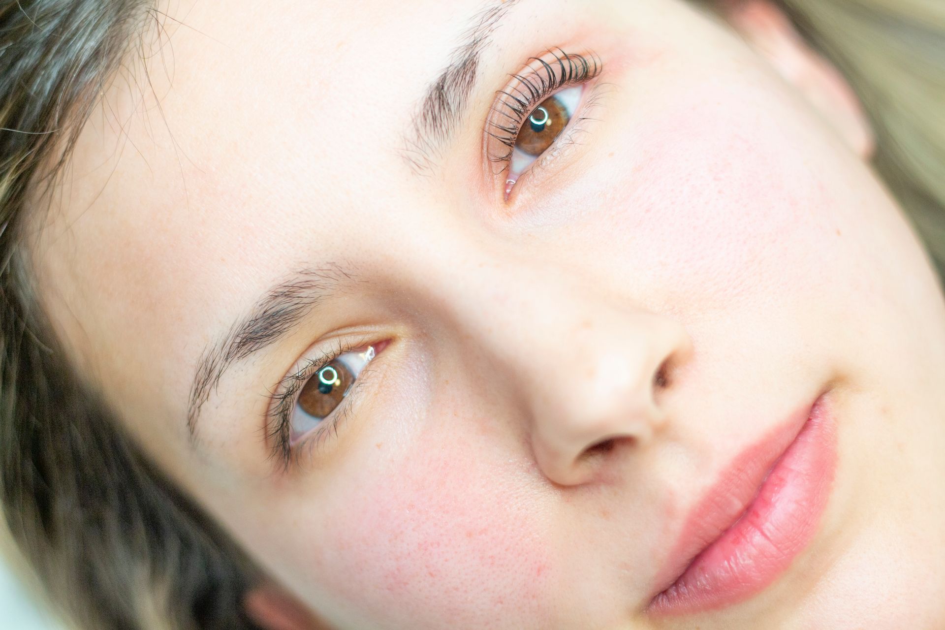 Un primo piano del viso di una donna senza trucco.