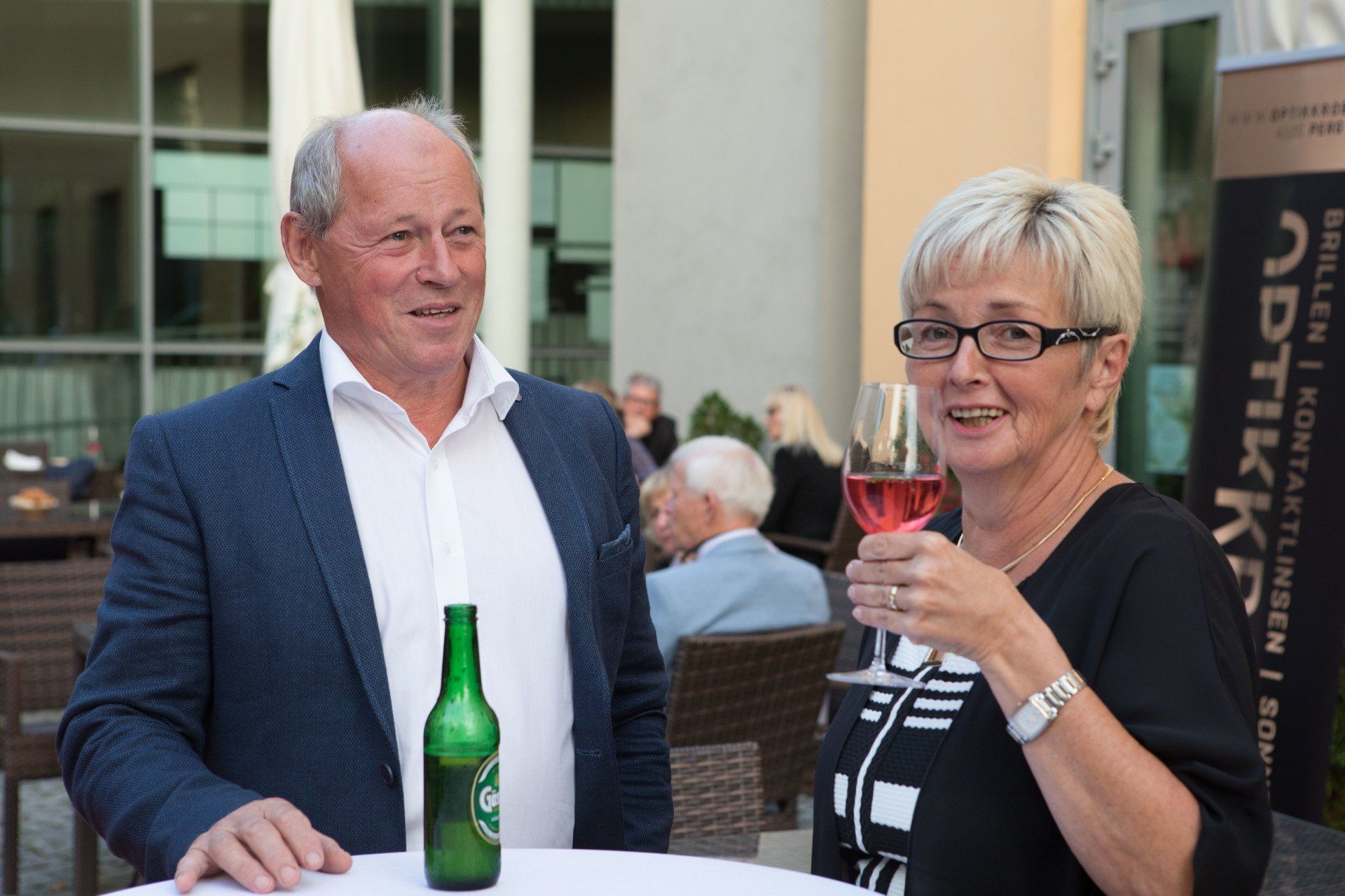 Ein Mann und eine Frau stehen nebeneinander und trinken Wein