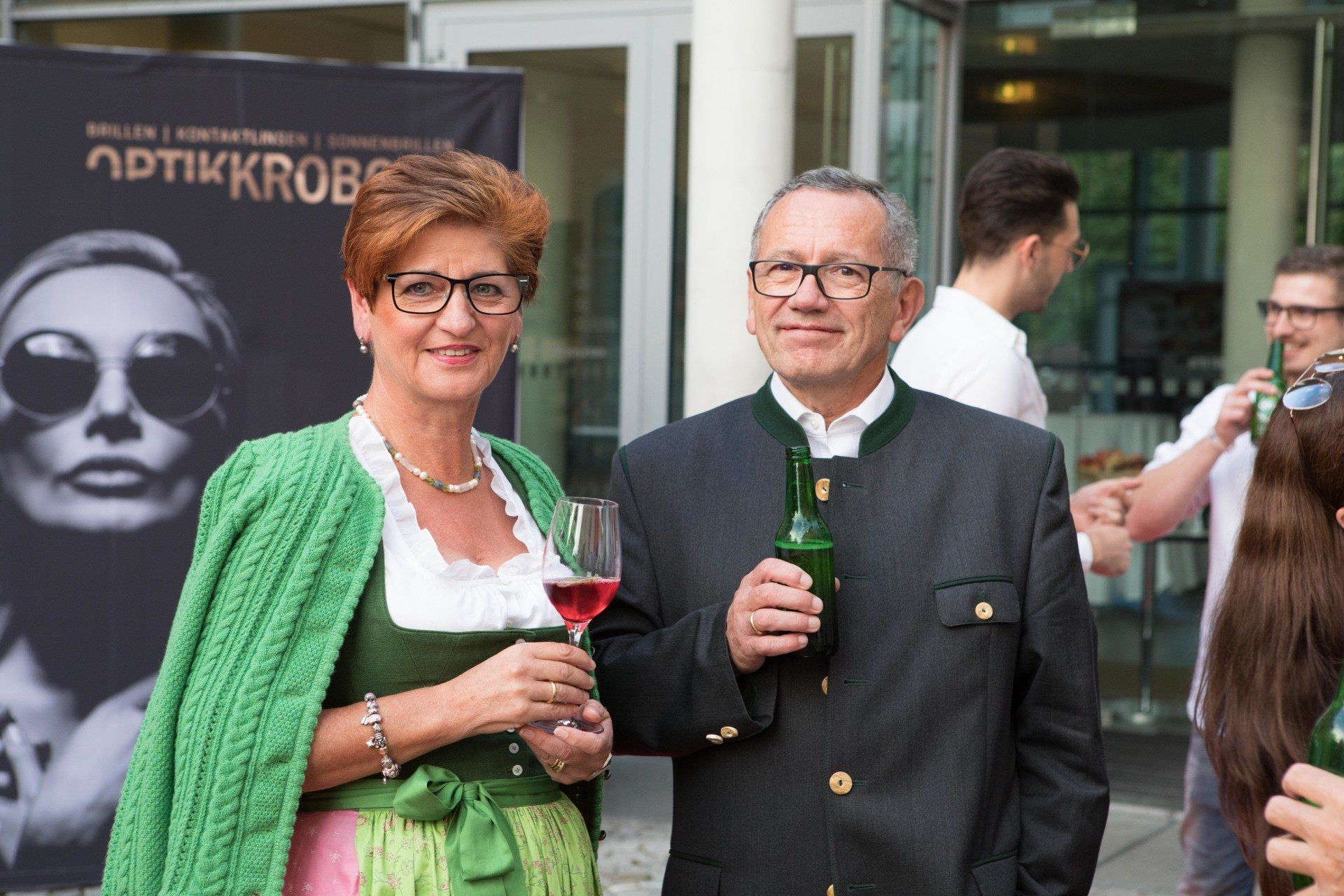 Ein Mann und eine Frau stehen nebeneinander und halten Weingläser.
