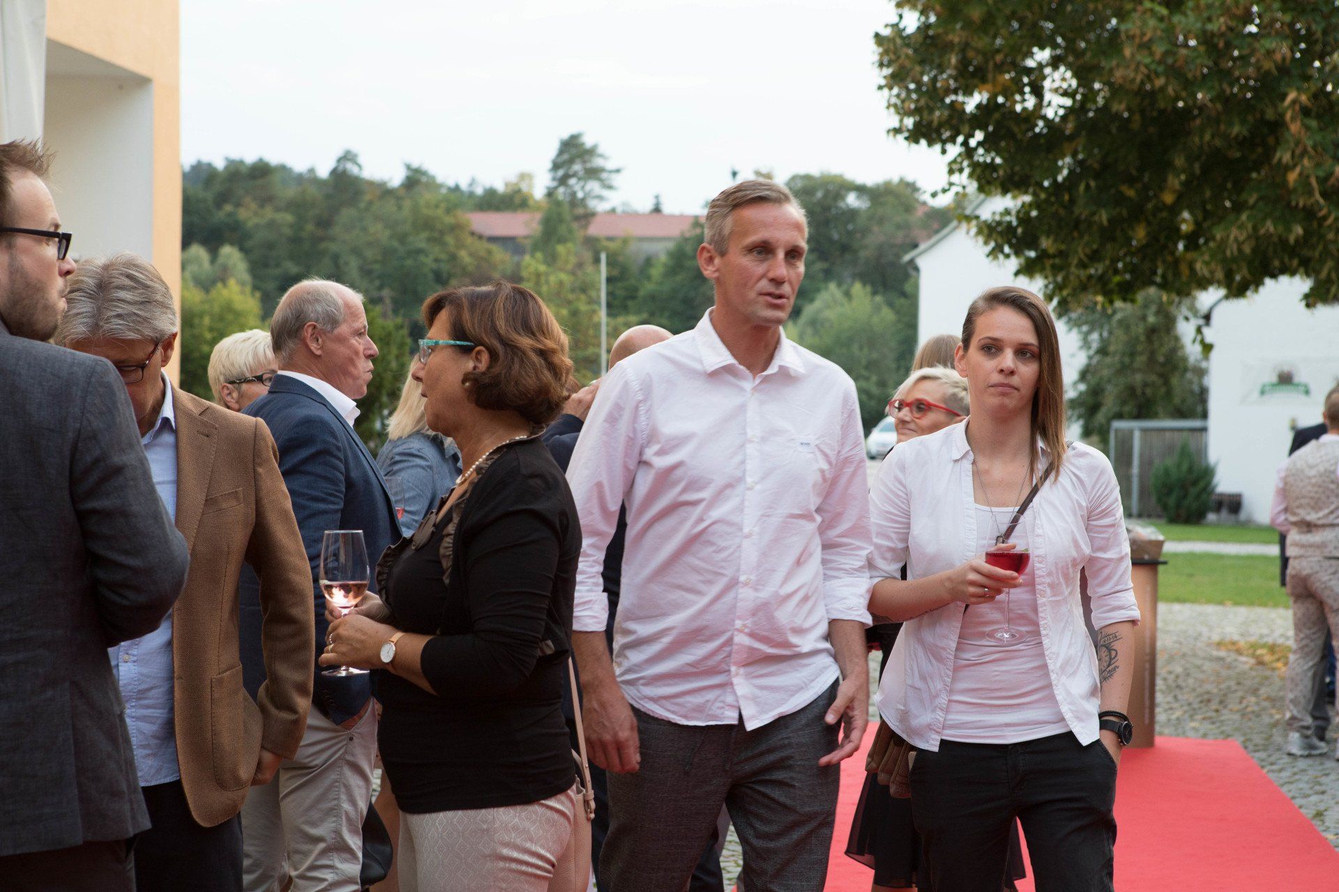 Eine Gruppe von Menschen steht auf einem roten Teppich.