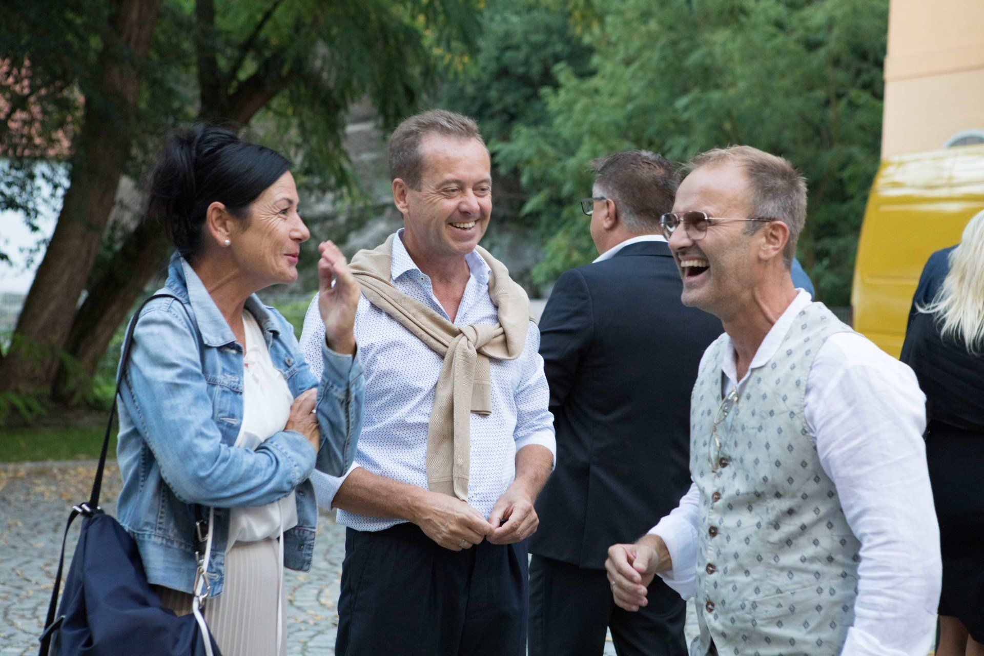 Eine Gruppe von Menschen steht nebeneinander und lacht.