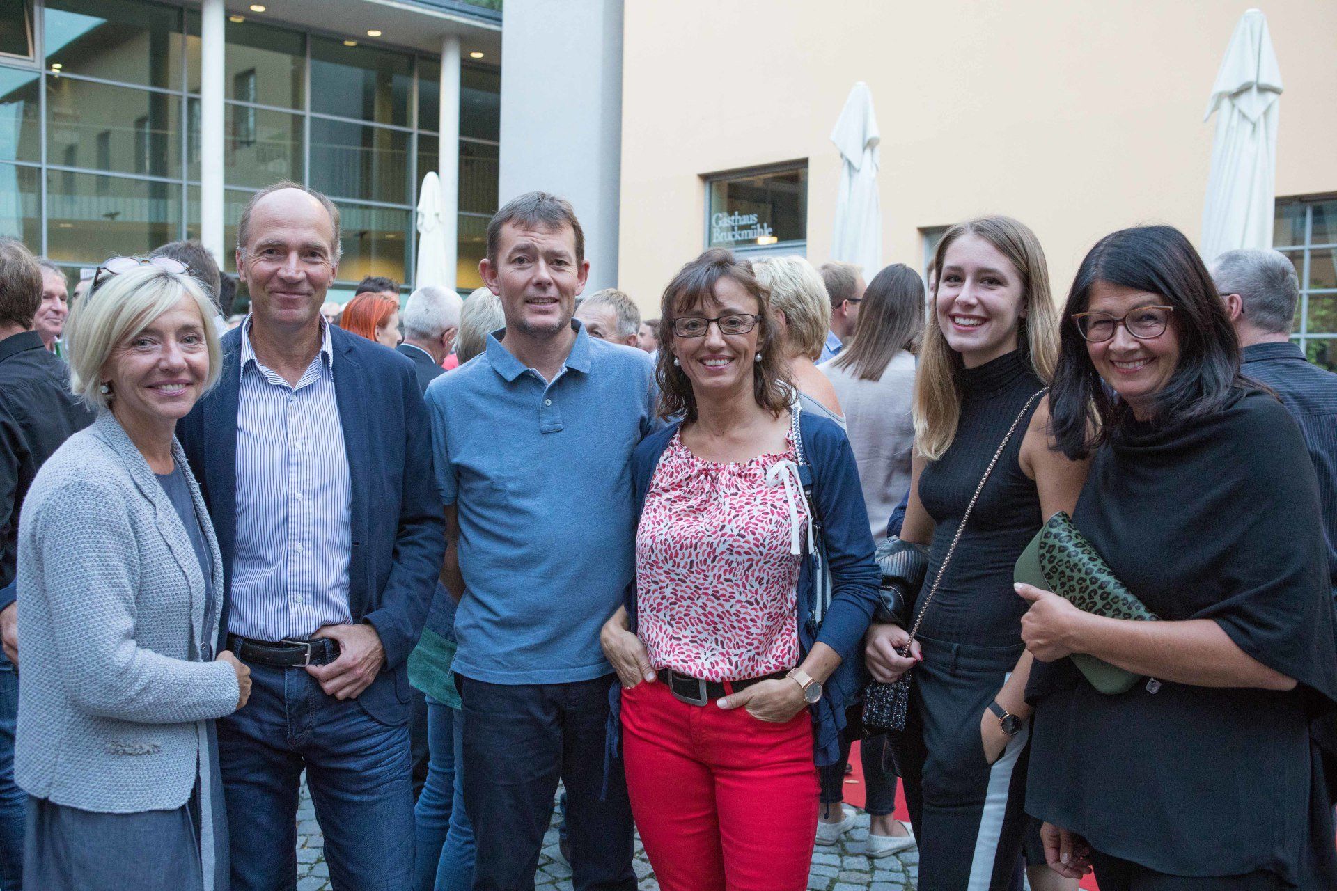 Eine Gruppe von Menschen posiert vor einem Gebäude für ein Foto.