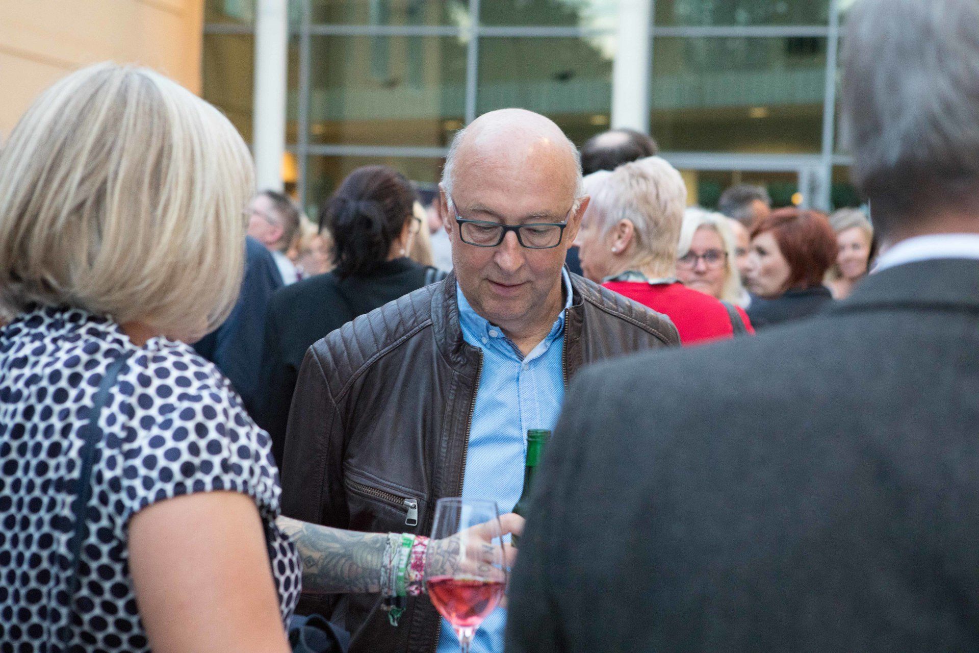 Ein Mann hält ein Glas Wein in der Hand, während er mit einer Frau spricht.