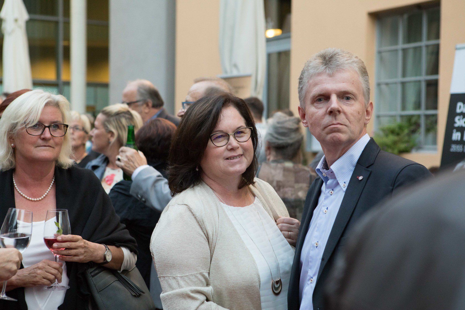 Ein Mann und eine Frau stehen in einer Menschenmenge nebeneinander.