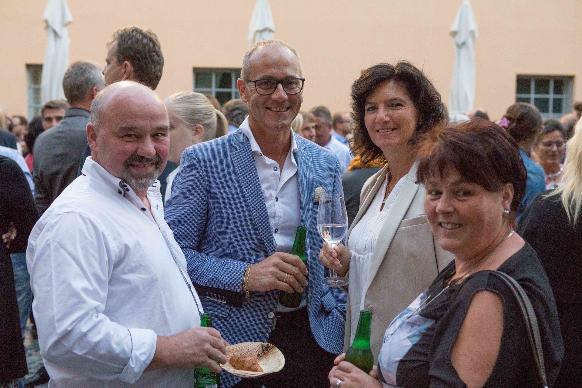 Eine Gruppe von Menschen steht in einer Menschenmenge nebeneinander.