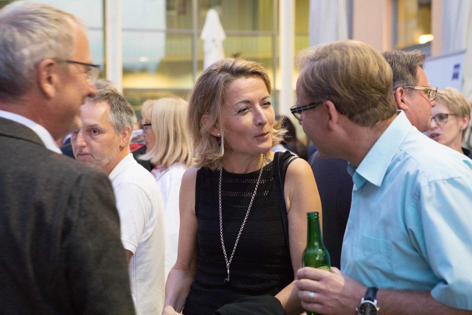 Eine Gruppe von Leuten steht herum und unterhält sich.