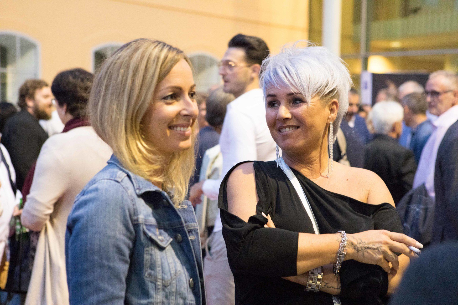 Zwei Frauen stehen in einer Menschenmenge nebeneinander.