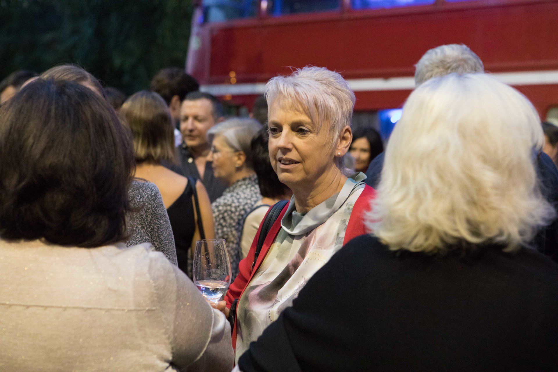 Eine Gruppe von Menschen steht in einer Menschenmenge und unterhält sich.