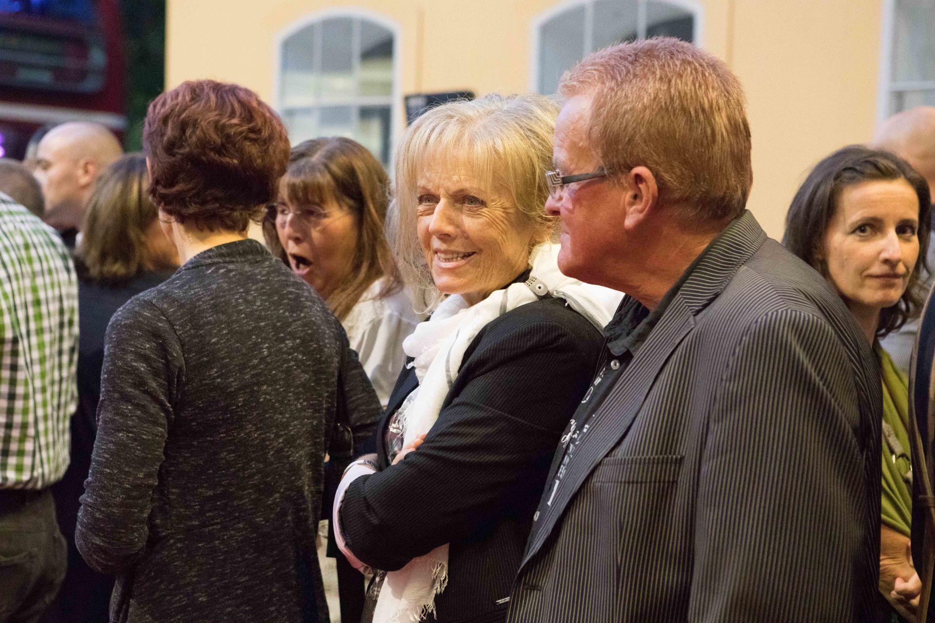 Eine Gruppe von Leuten steht in einem Raum und unterhält sich.