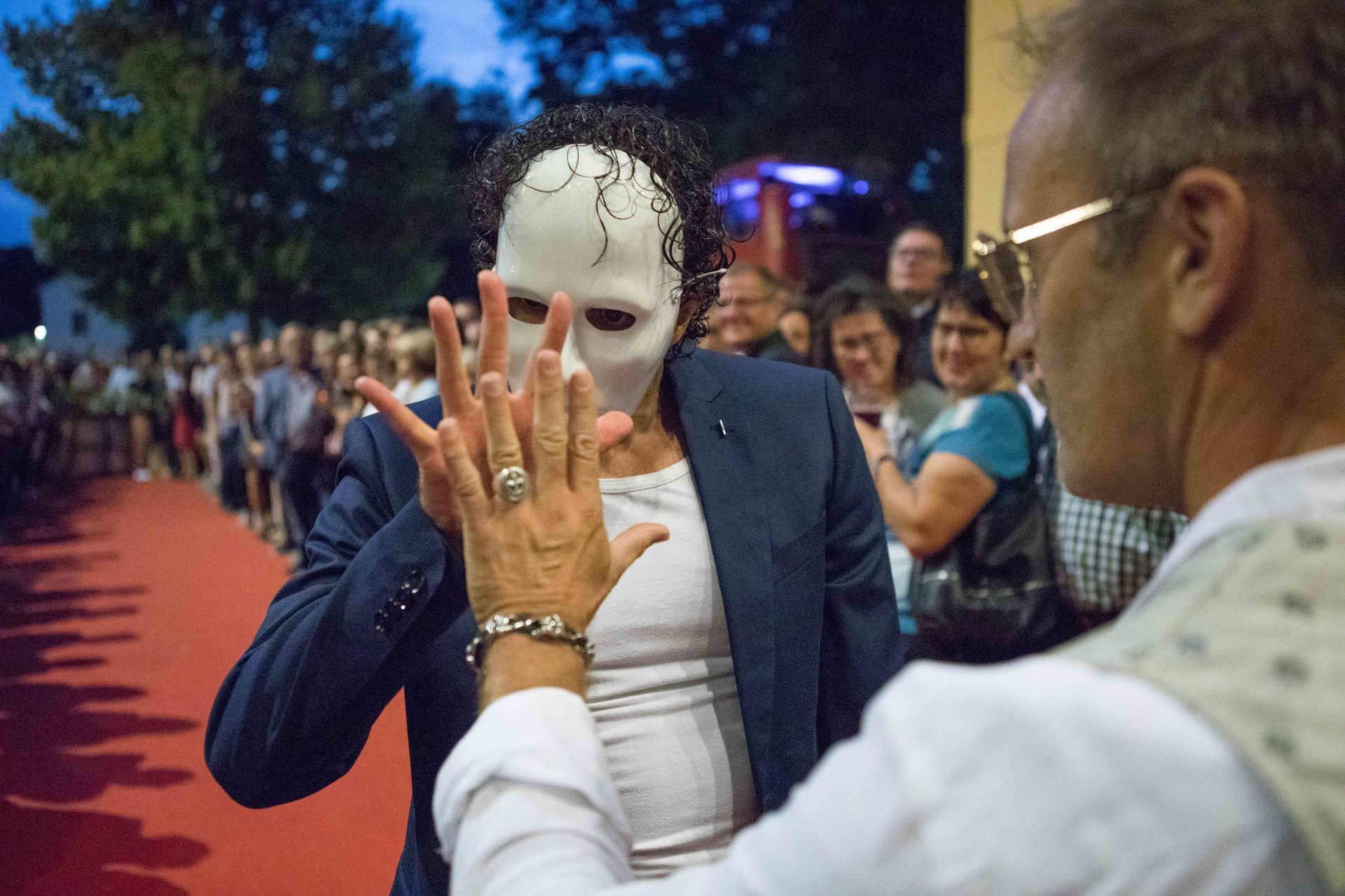Ein Mann mit einer Maske steht neben einer Frau, die eine Maske trägt.