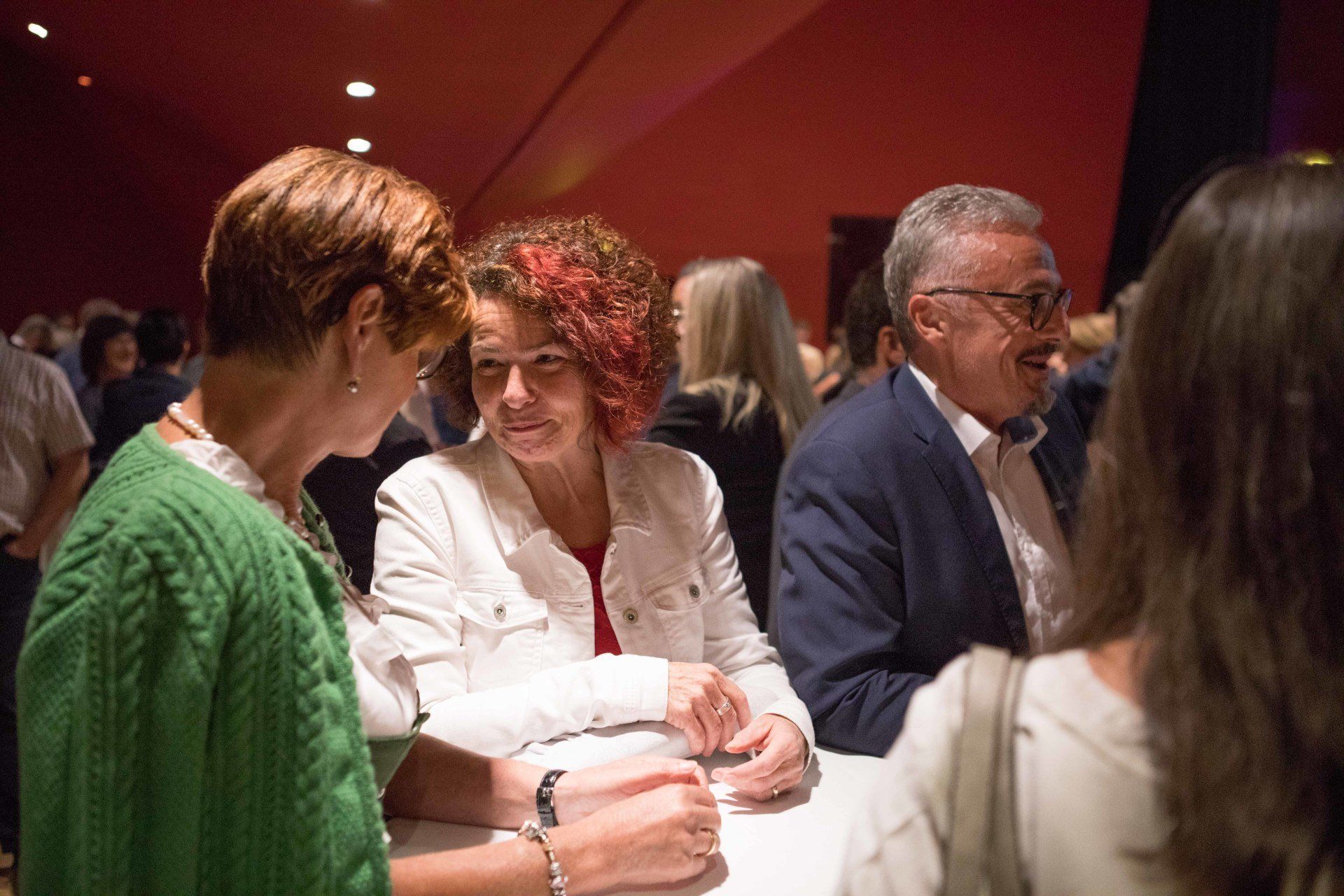 Eine Gruppe von Leuten sitzt an einem Tisch und unterhält sich.