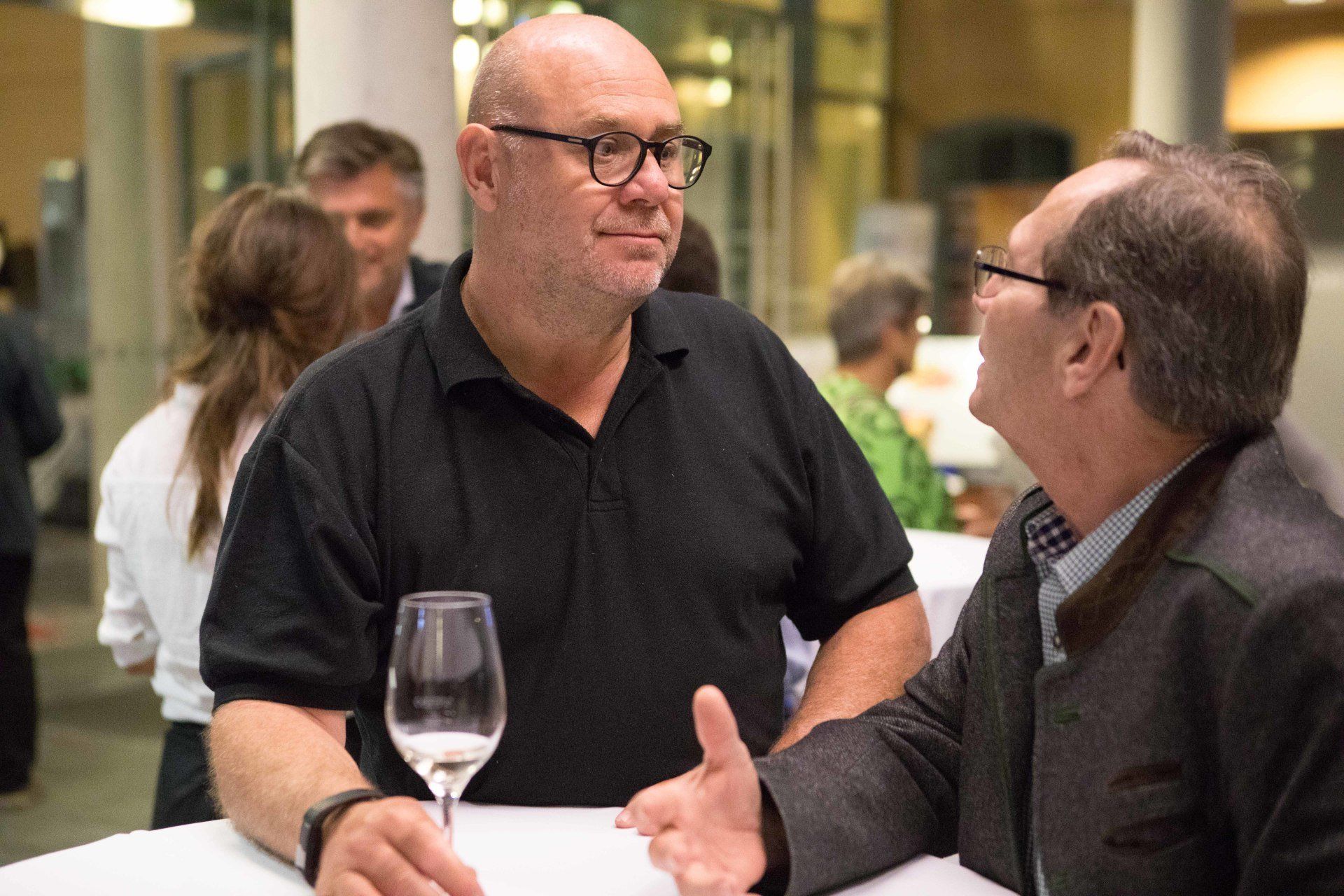 Zwei Männer sitzen an einem Tisch und unterhalten sich.