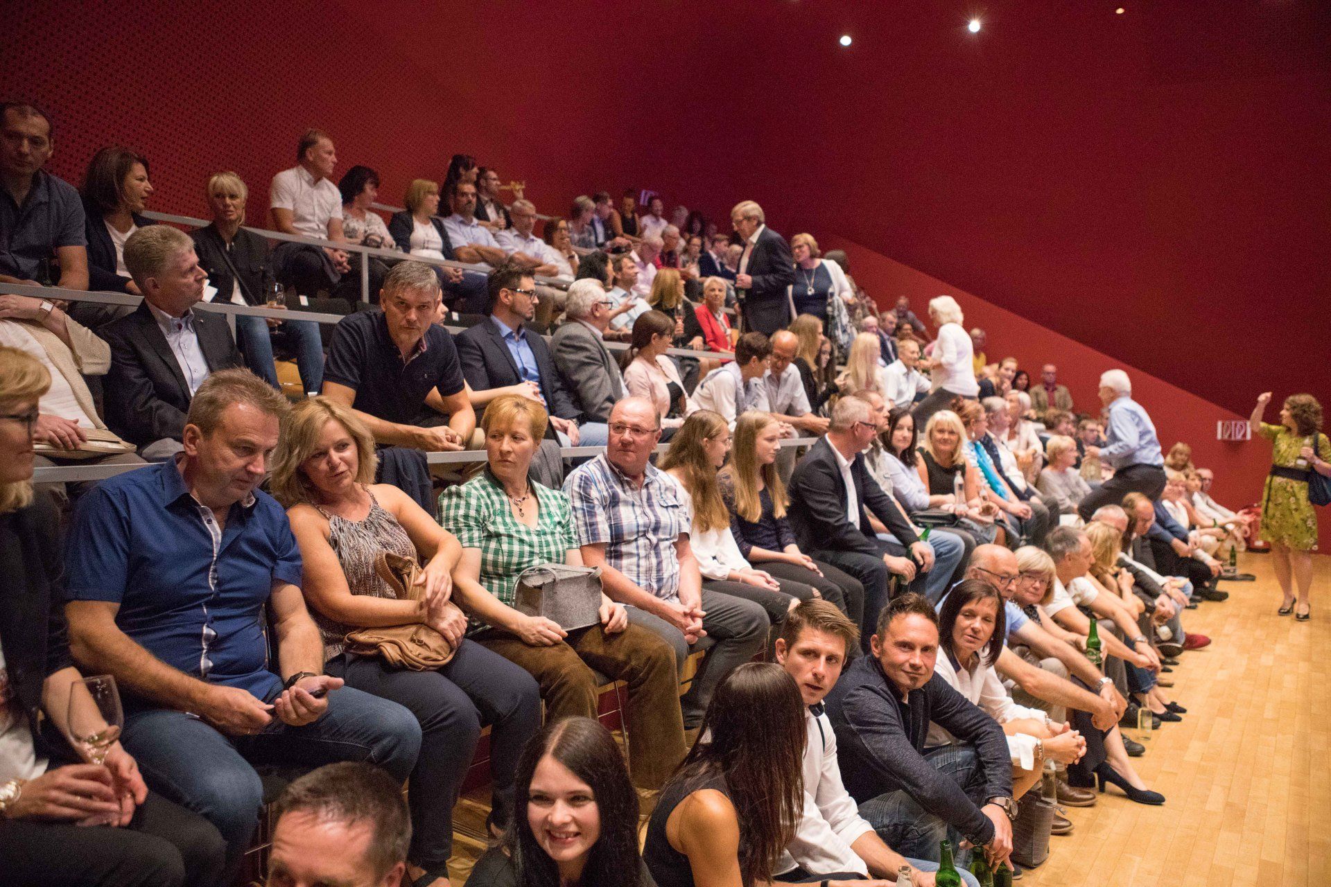 Eine große Gruppe von Menschen sitzt in einem Auditorium.