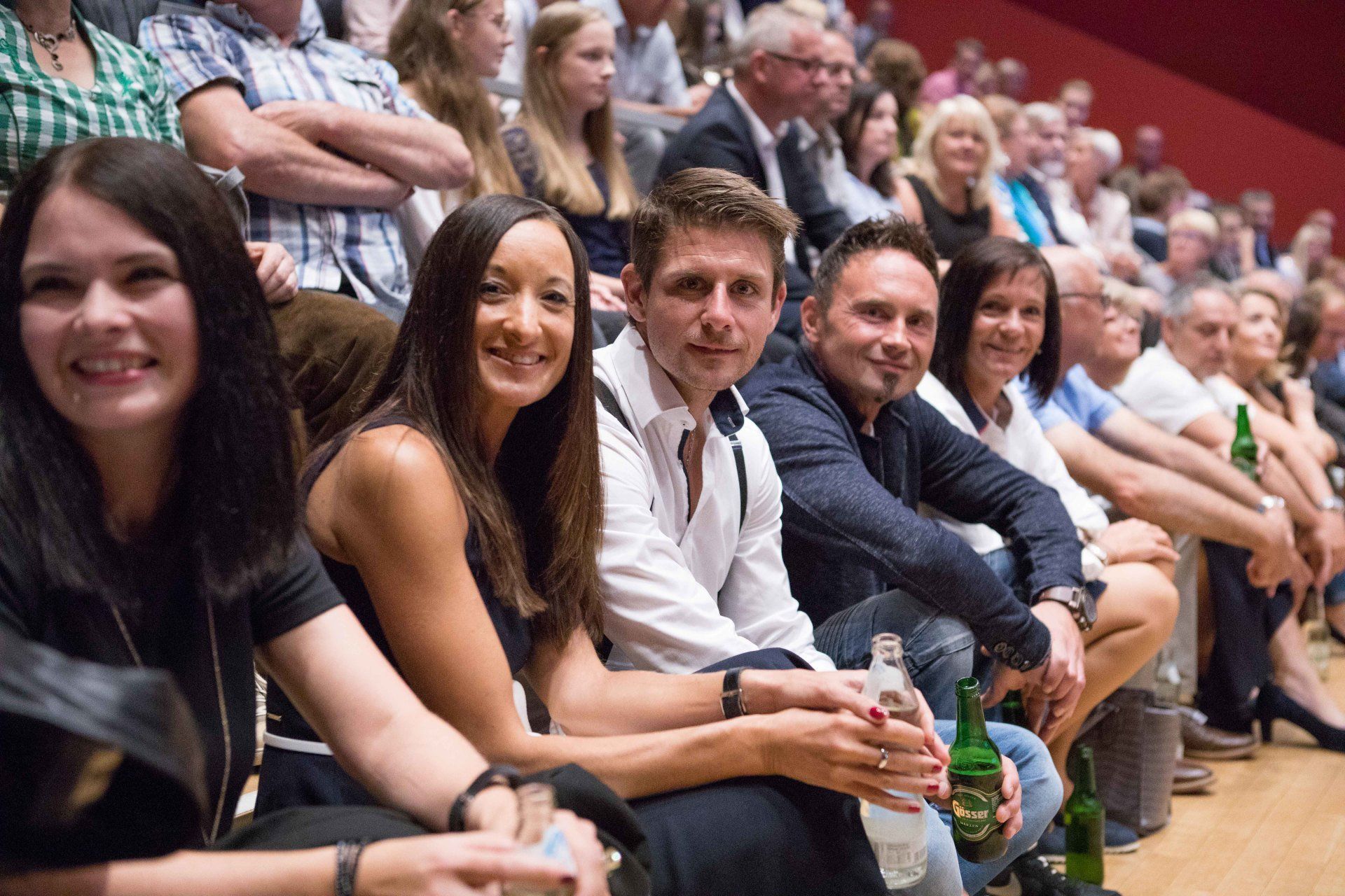 Eine Gruppe von Menschen sitzt in einem Stadion.