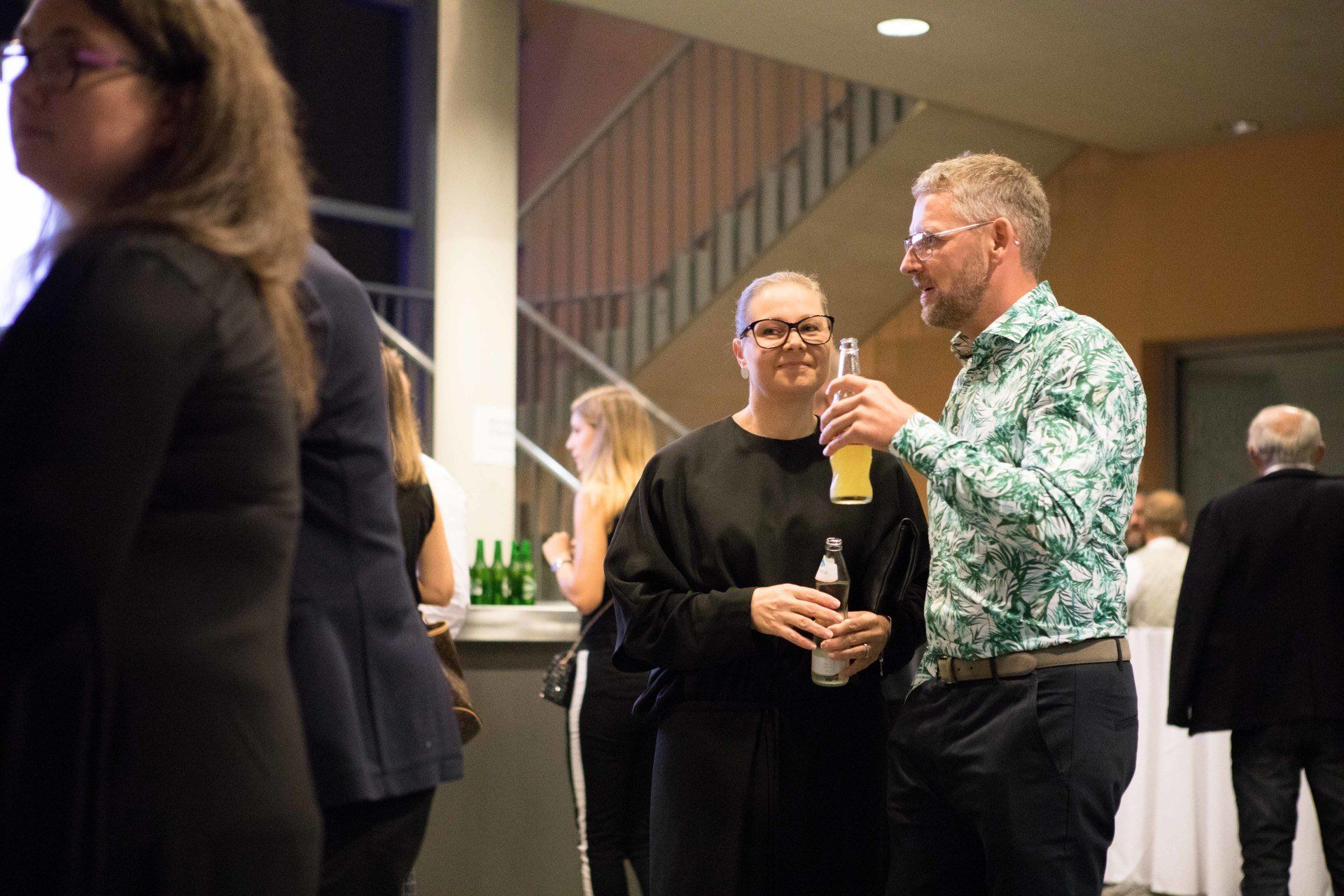 Eine Gruppe von Leuten steht in einem Raum und unterhält sich.
