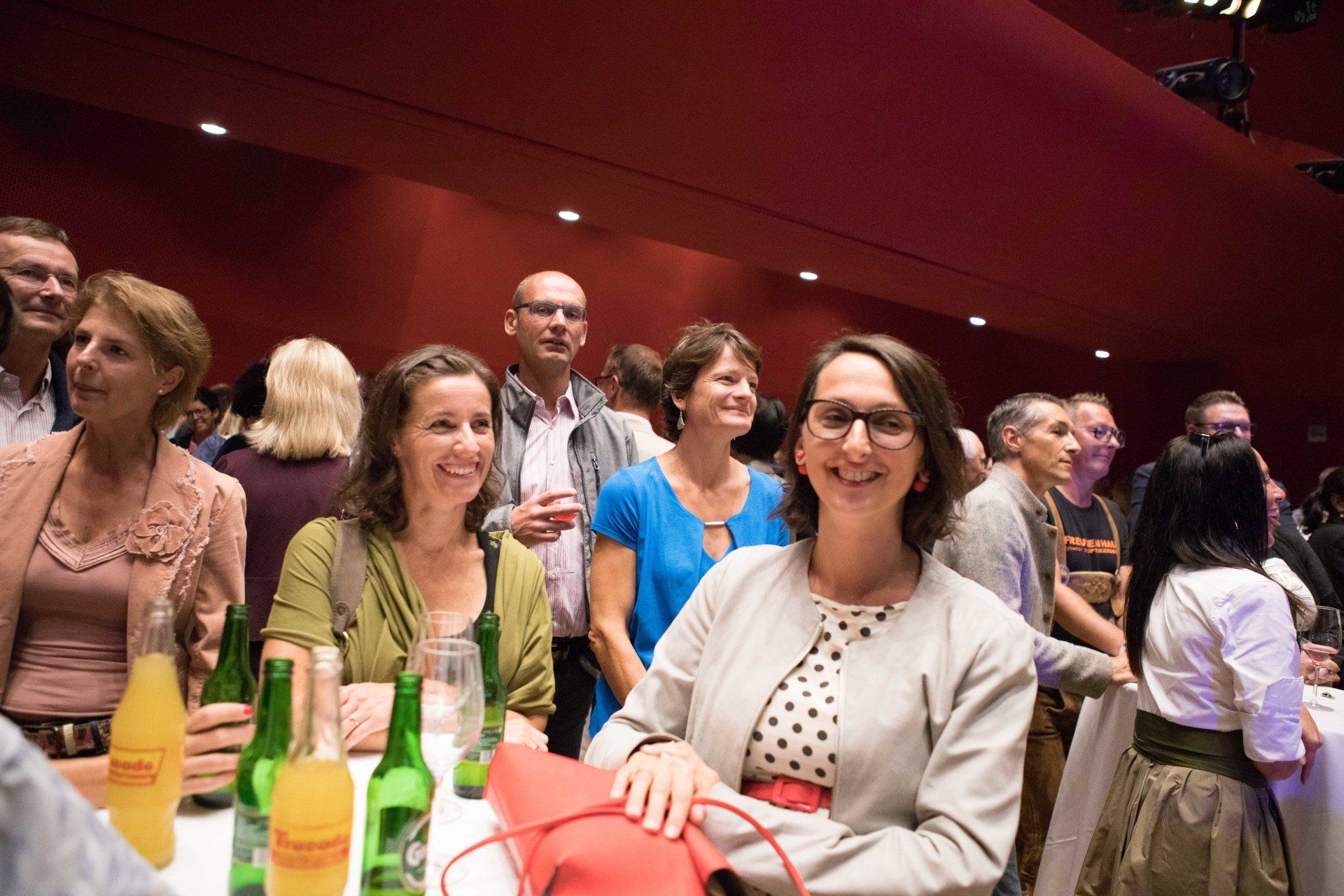 Eine Gruppe von Leuten sitzt mit Getränken an einem Tisch.