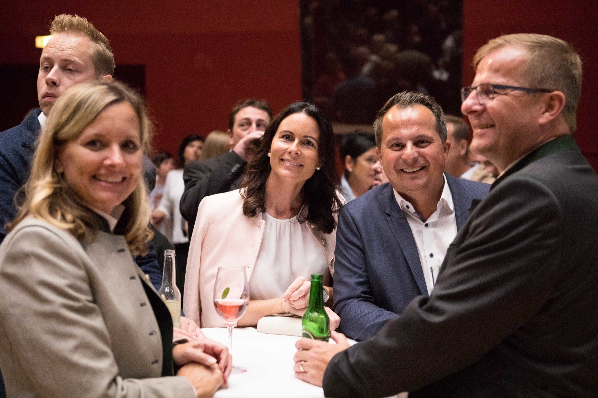 Eine Gruppe von Leuten sitzt um einen Tisch herum und trinkt Wein.