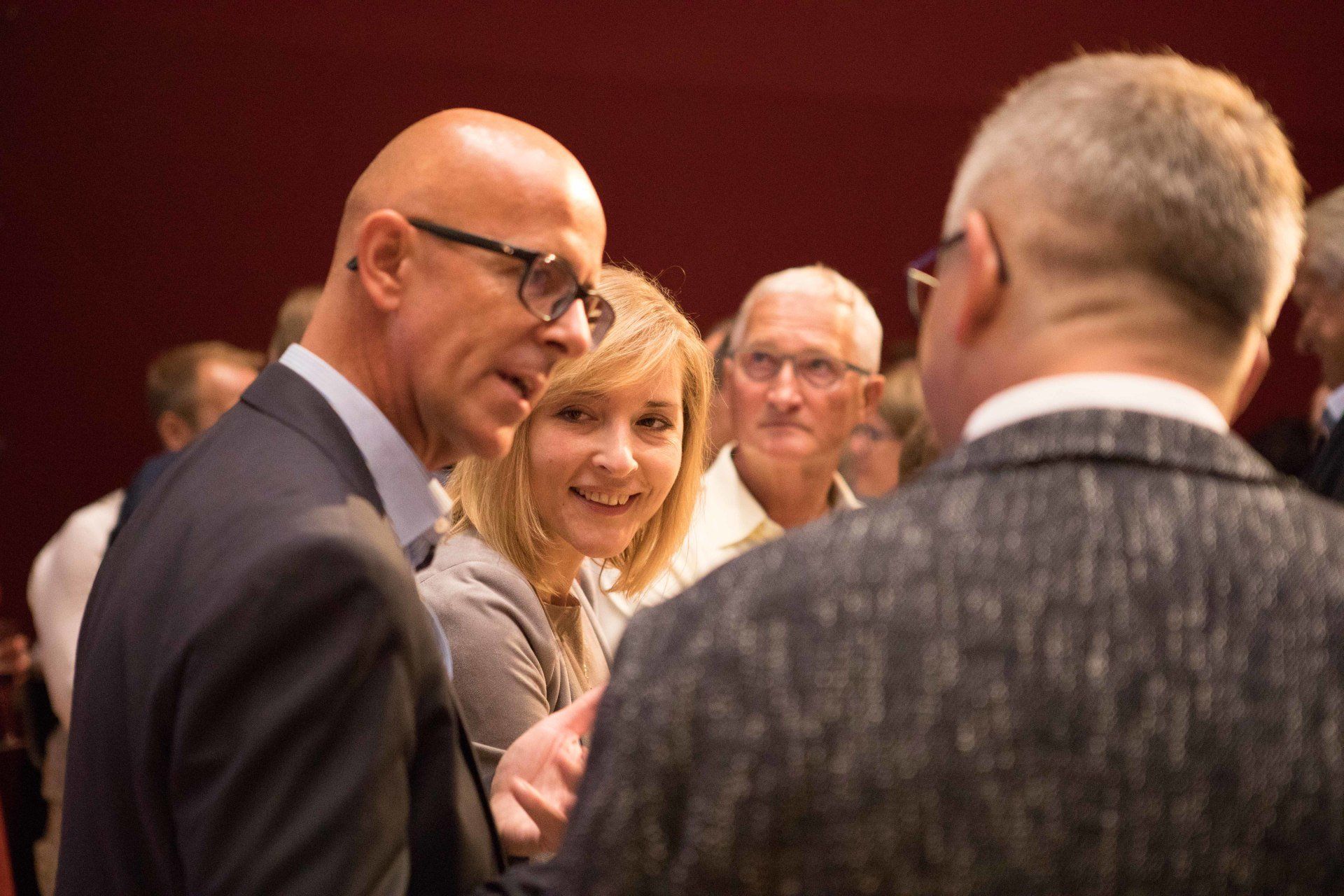 Eine Gruppe von Menschen unterhält sich in einem Raum miteinander.