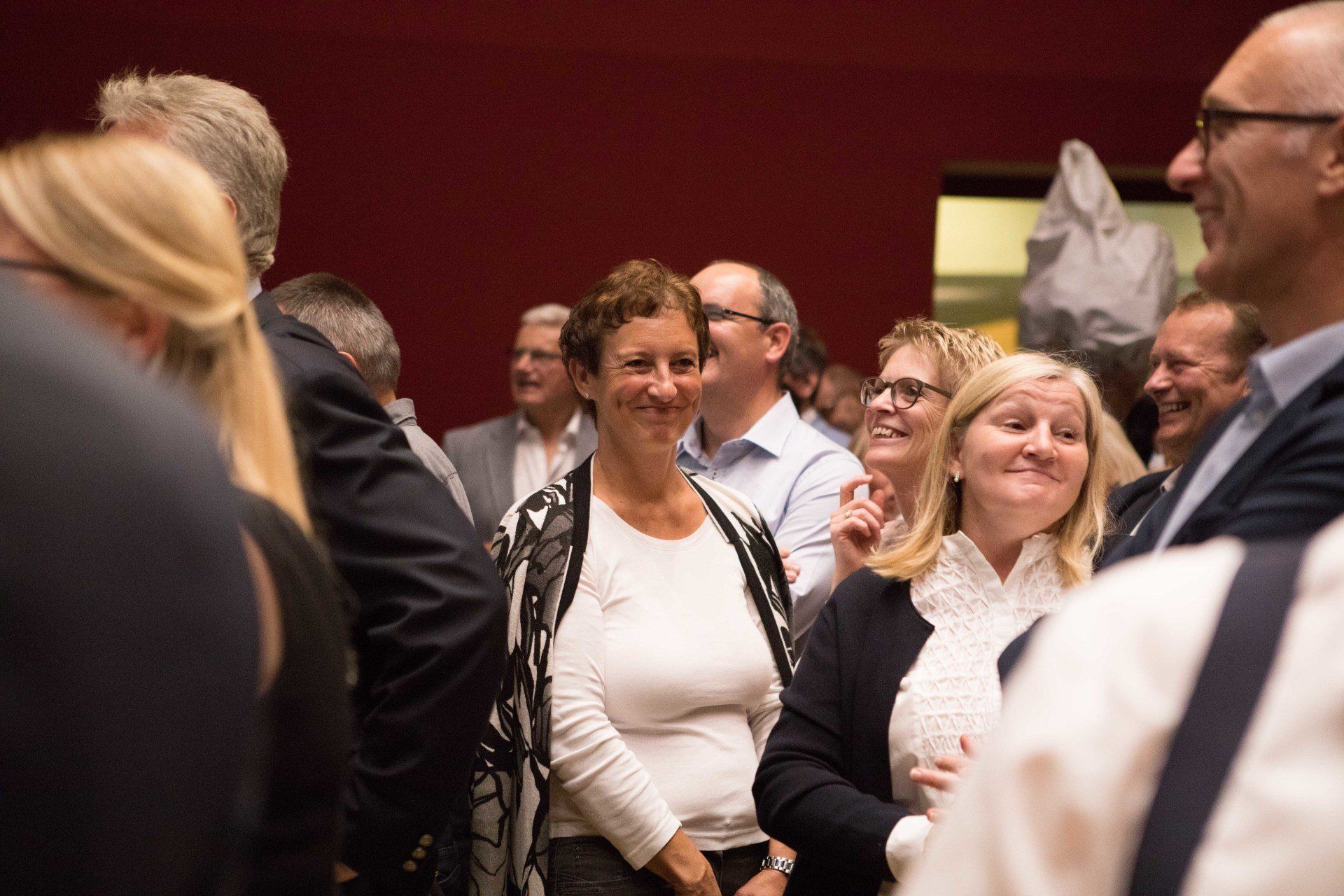 Eine Gruppe von Menschen steht in einem Raum und lächelt.