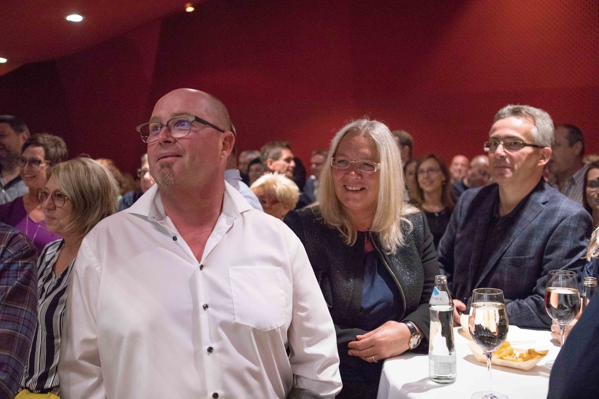 Eine Gruppe von Menschen sitzt in einem Raum an einem Tisch.