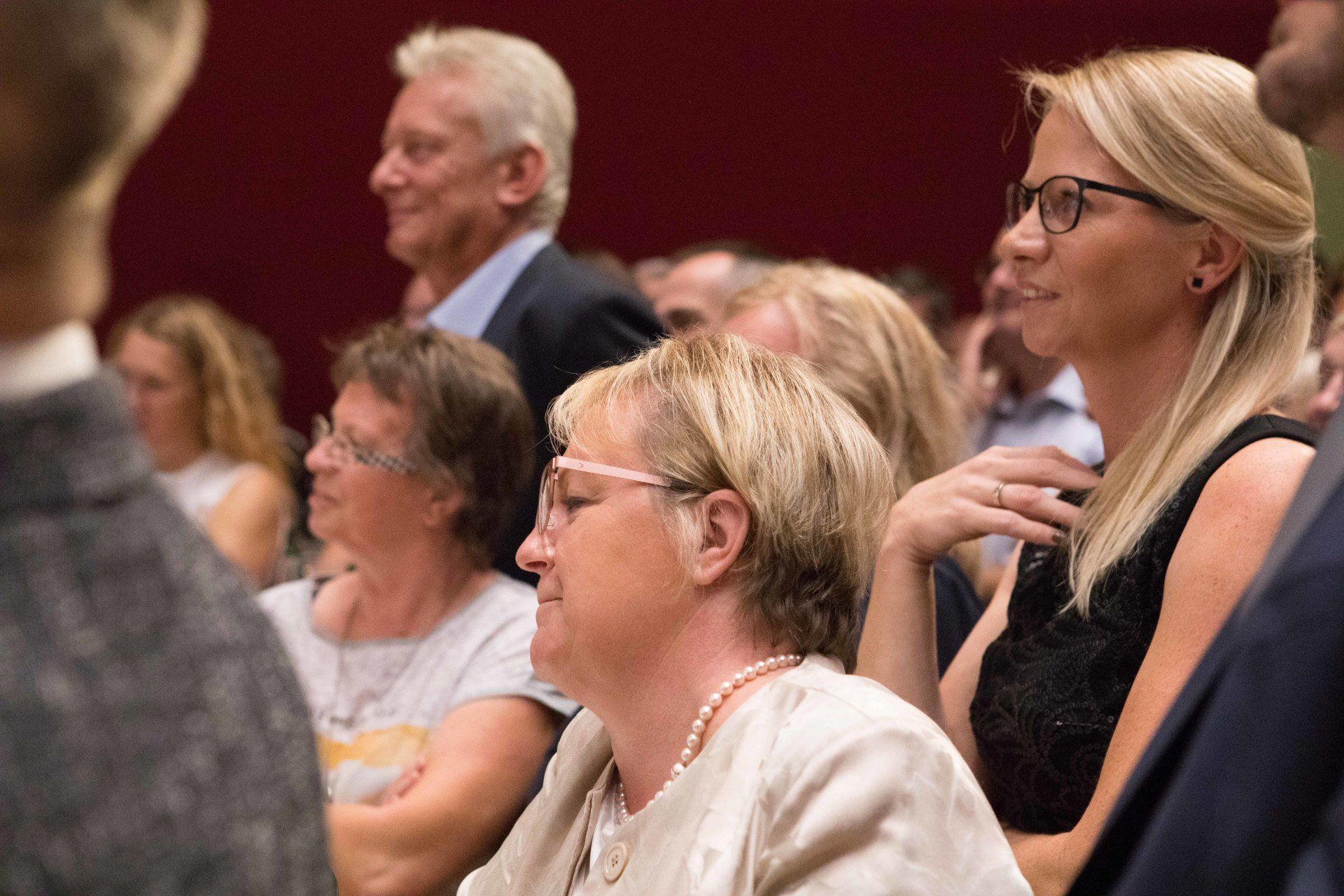Eine Gruppe von Leuten sitzt in einem Raum und sieht sich eine Präsentation an.