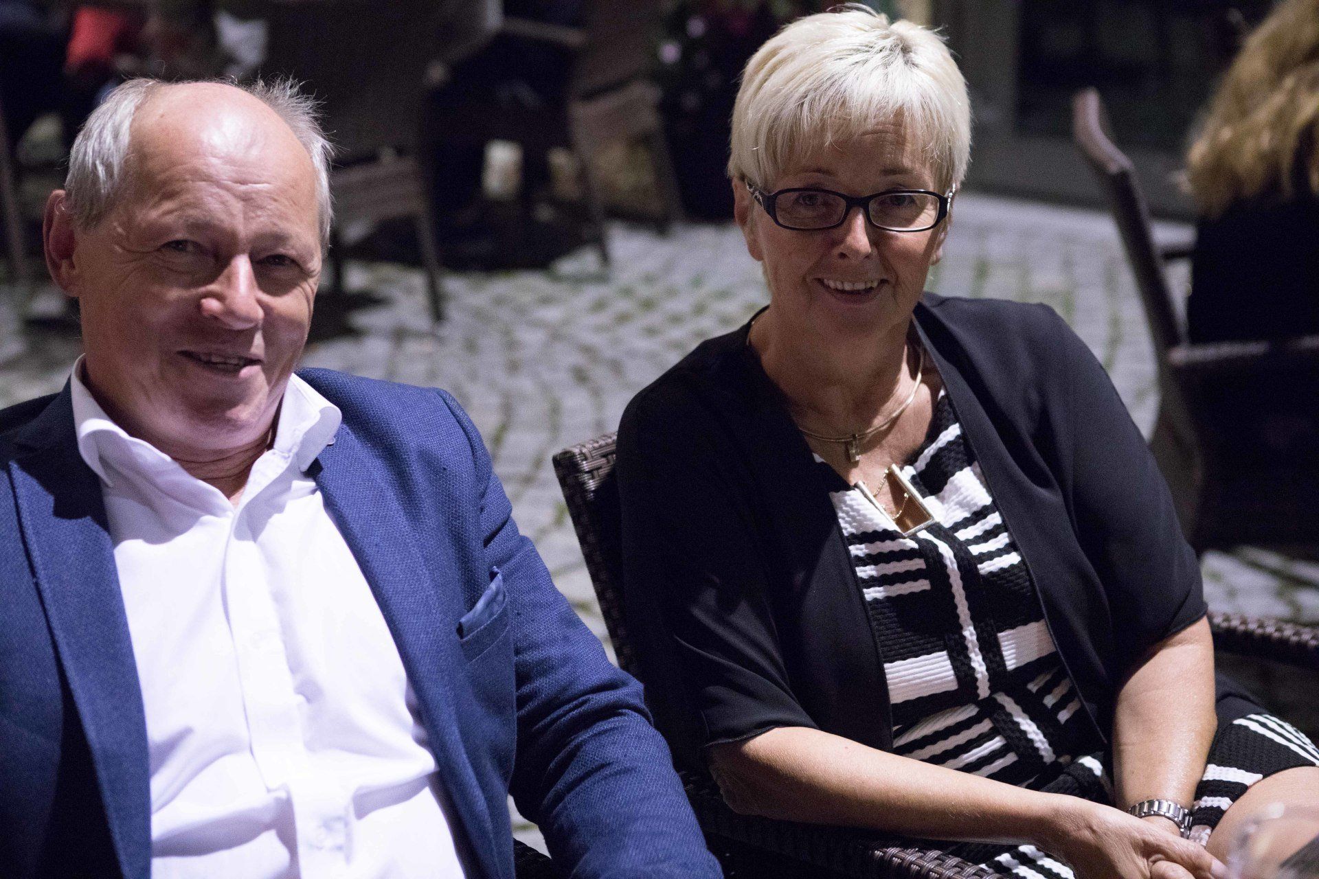 Ein Mann und eine Frau sitzen nebeneinander und lächeln.