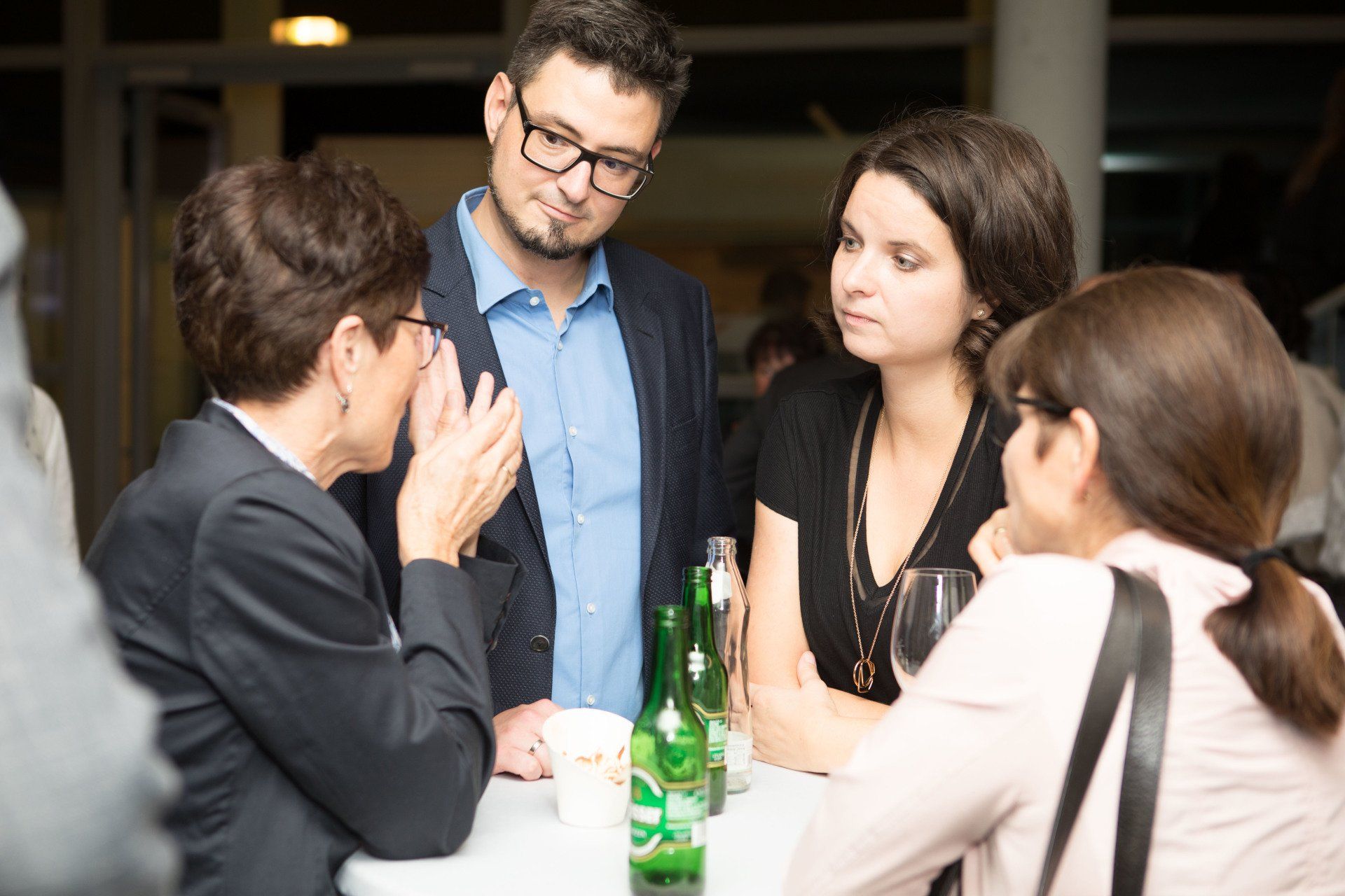 Eine Gruppe von Leuten sitzt um einen Tisch herum und unterhält sich.