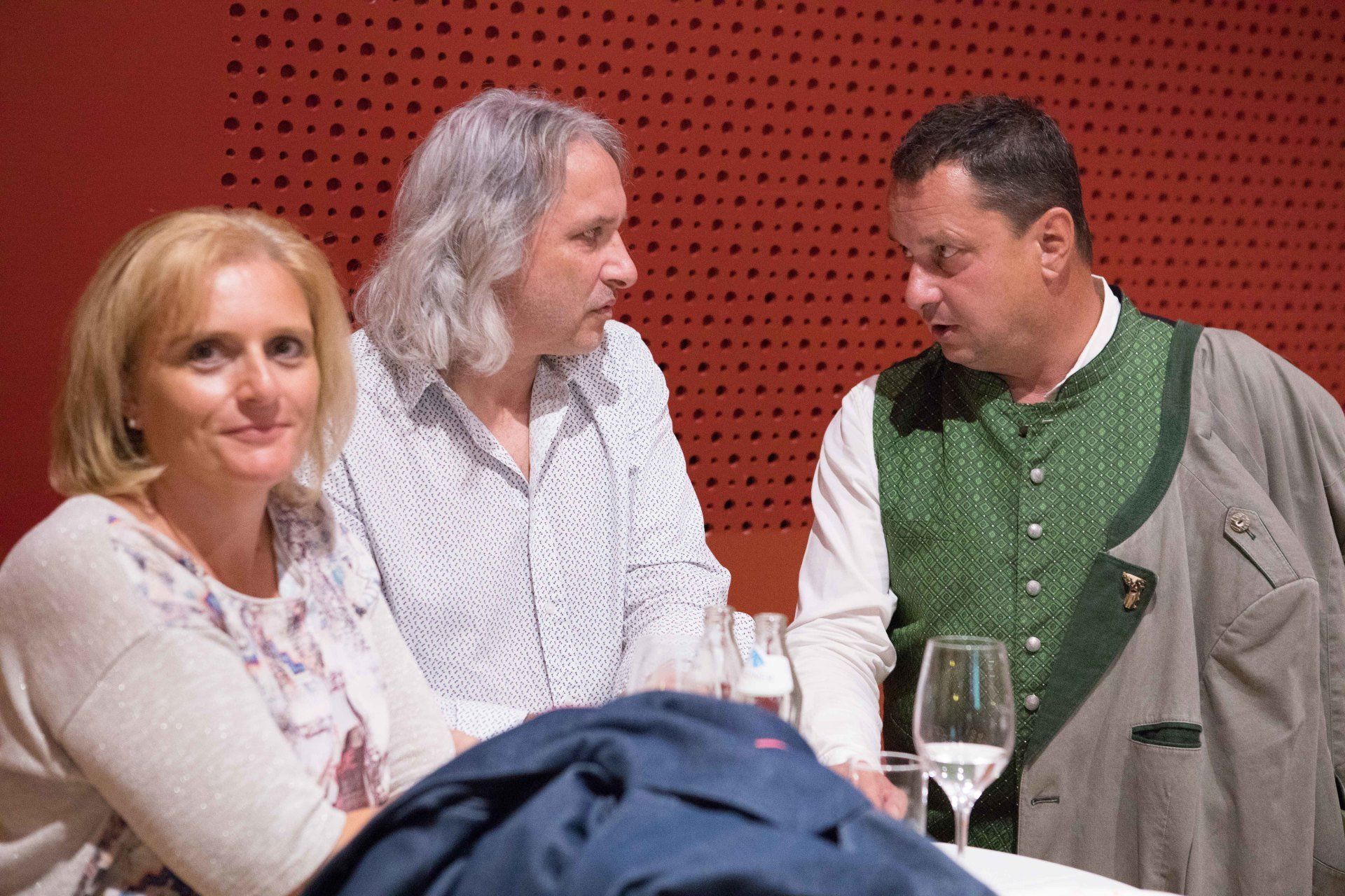 Eine Gruppe von Leuten sitzt an einem Tisch und unterhält sich.