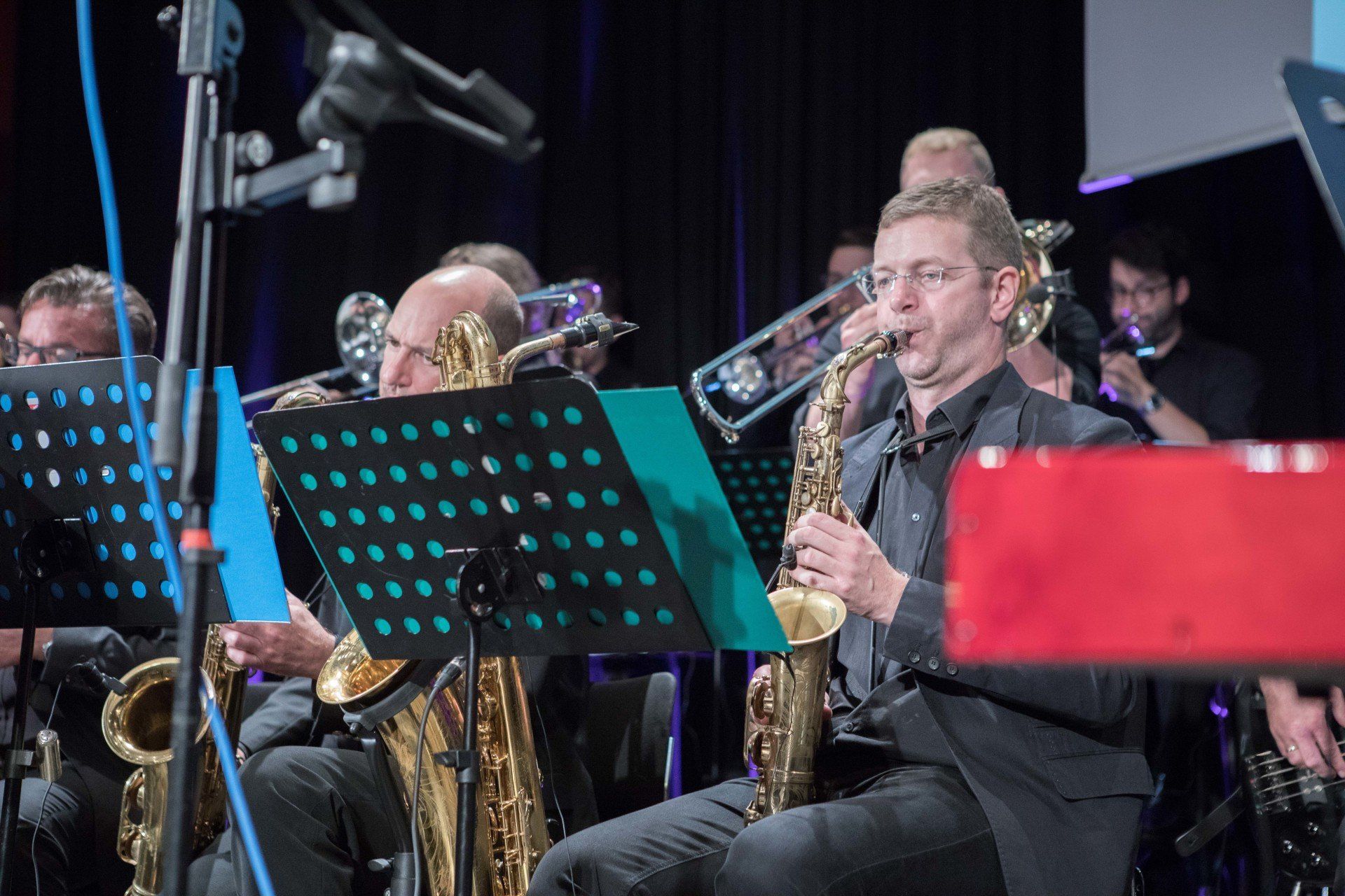 Ein Mann spielt Saxophon in einem Orchester.