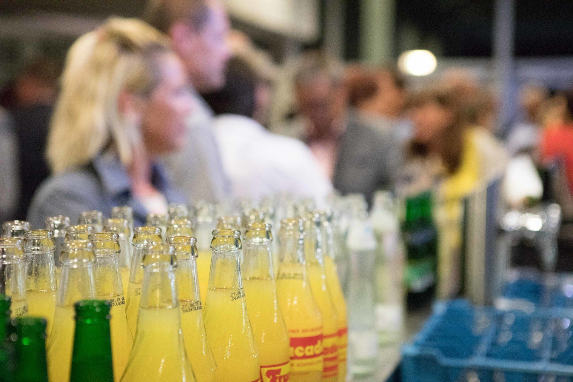 Auf einem Tisch stehen mehrere Flaschen Limonade aufgereiht.