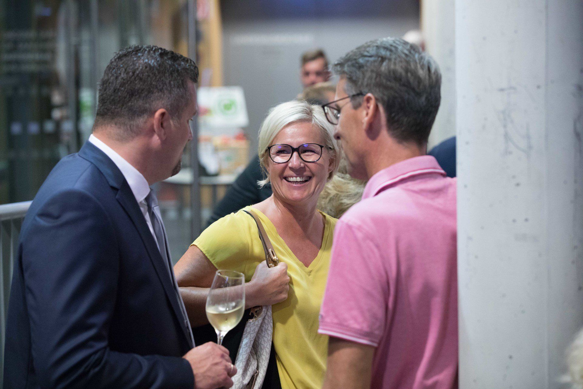 Eine Gruppe von Menschen steht nebeneinander und unterhält sich.