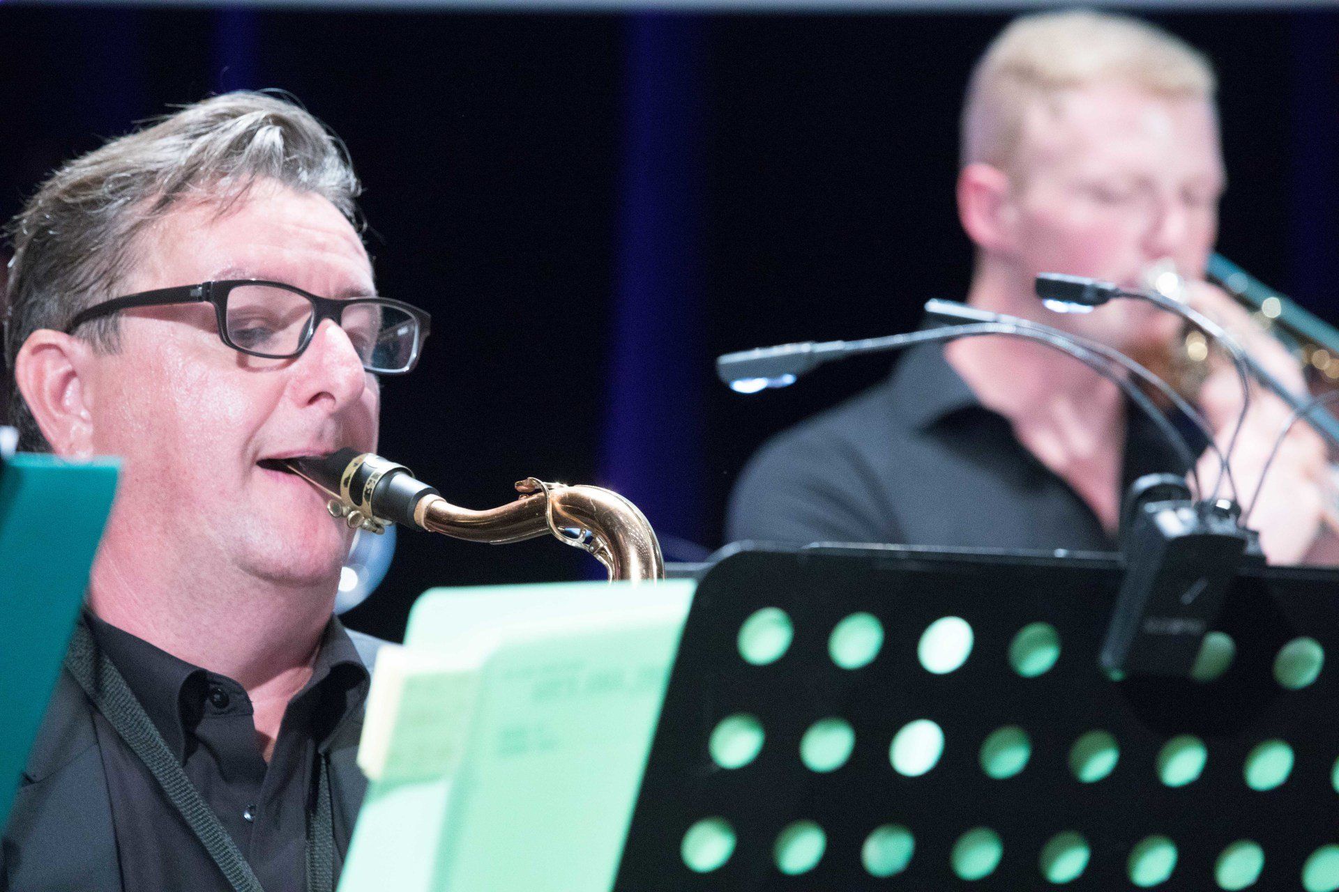 Ein Mann spielt Saxophon, während ein anderer Mann Posaune spielt