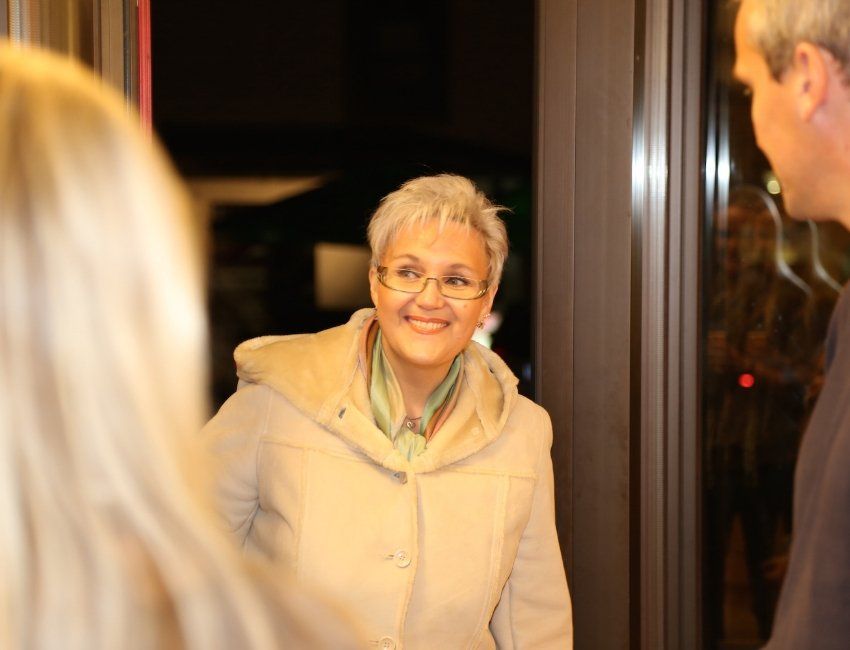 Eine Frau mit Brille steht lächelnd neben einem Mann.