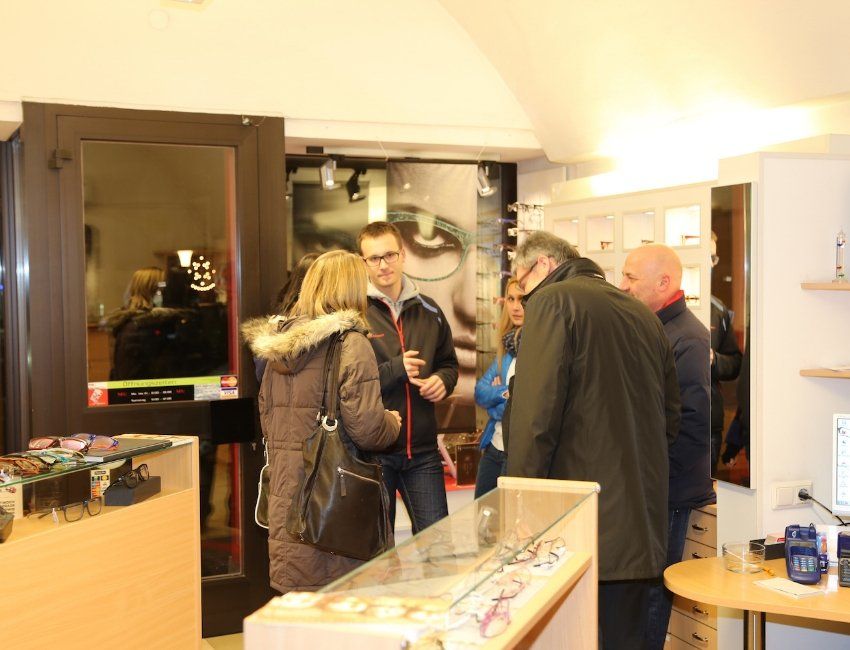 Eine Gruppe von Menschen steht in einem Geschäft und schaut sich Brillen an