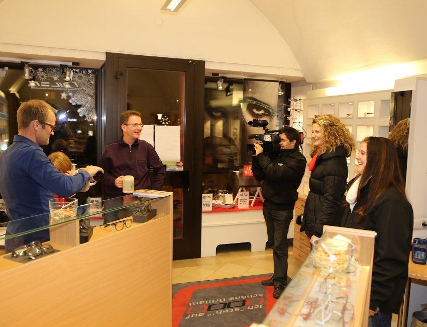 Eine Gruppe von Menschen steht um eine Theke in einem Geschäft herum