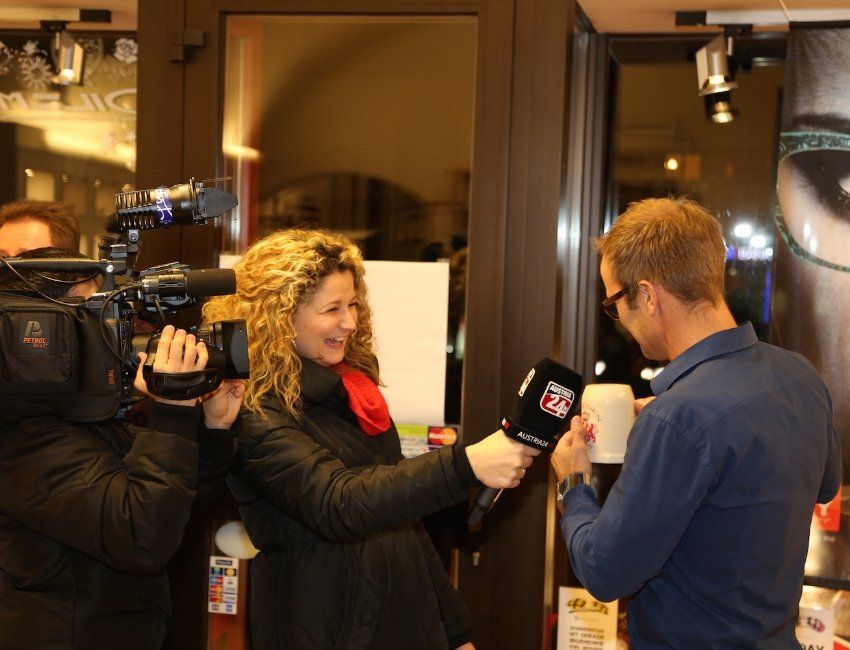 Ein Mann hält ein Mikrofon und spricht mit einer Frau