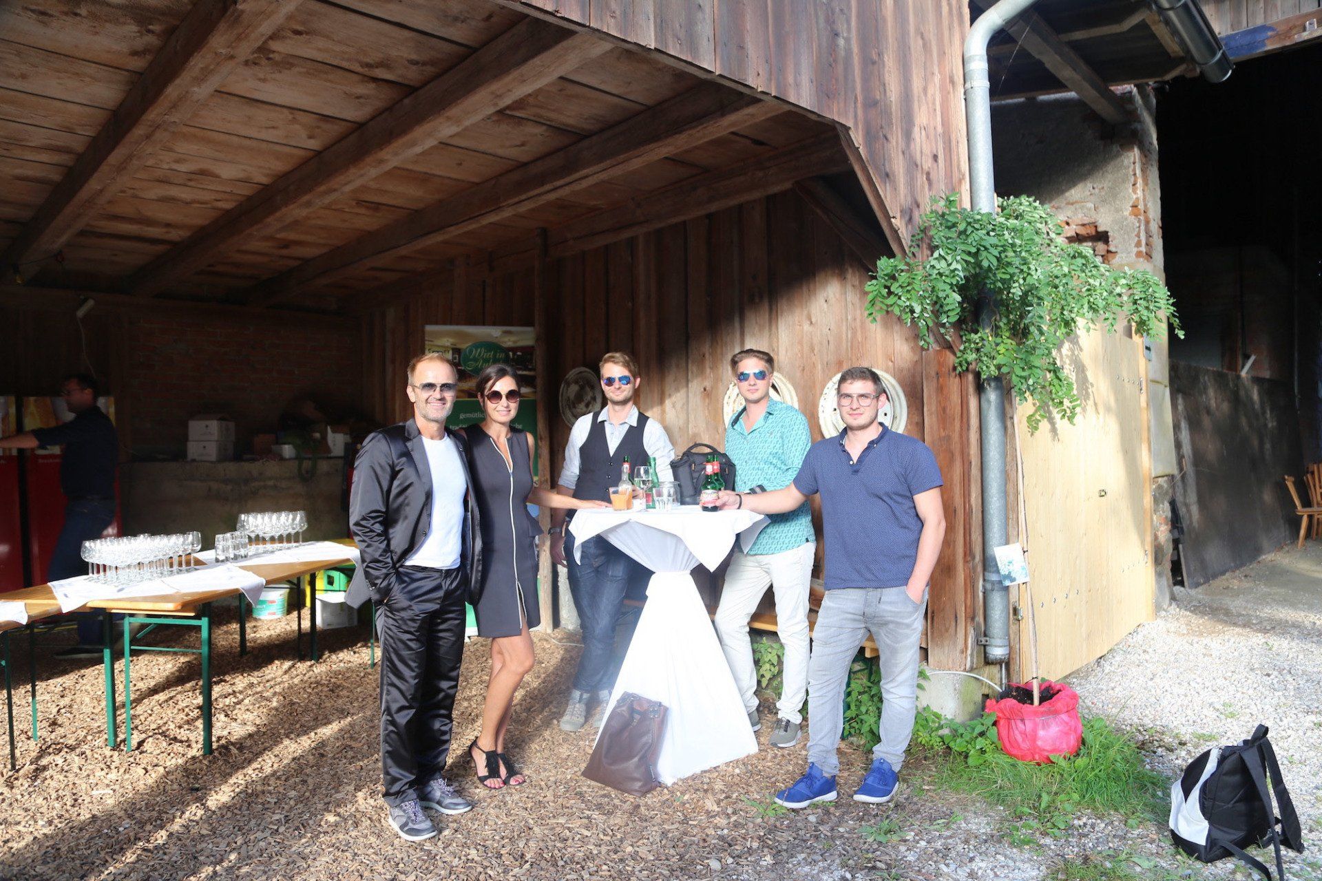 Eine Gruppe von Menschen steht vor einem Holzgebäude.