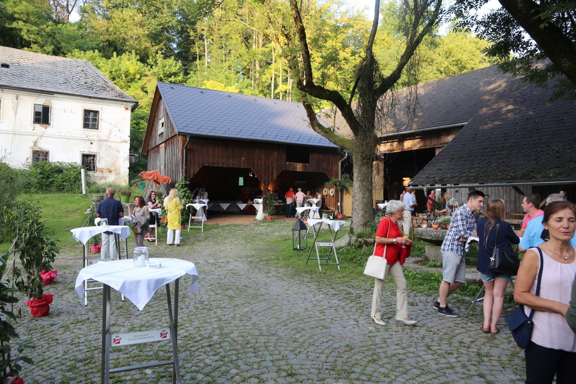 Eine Gruppe von Menschen steht vor einer Scheune.
