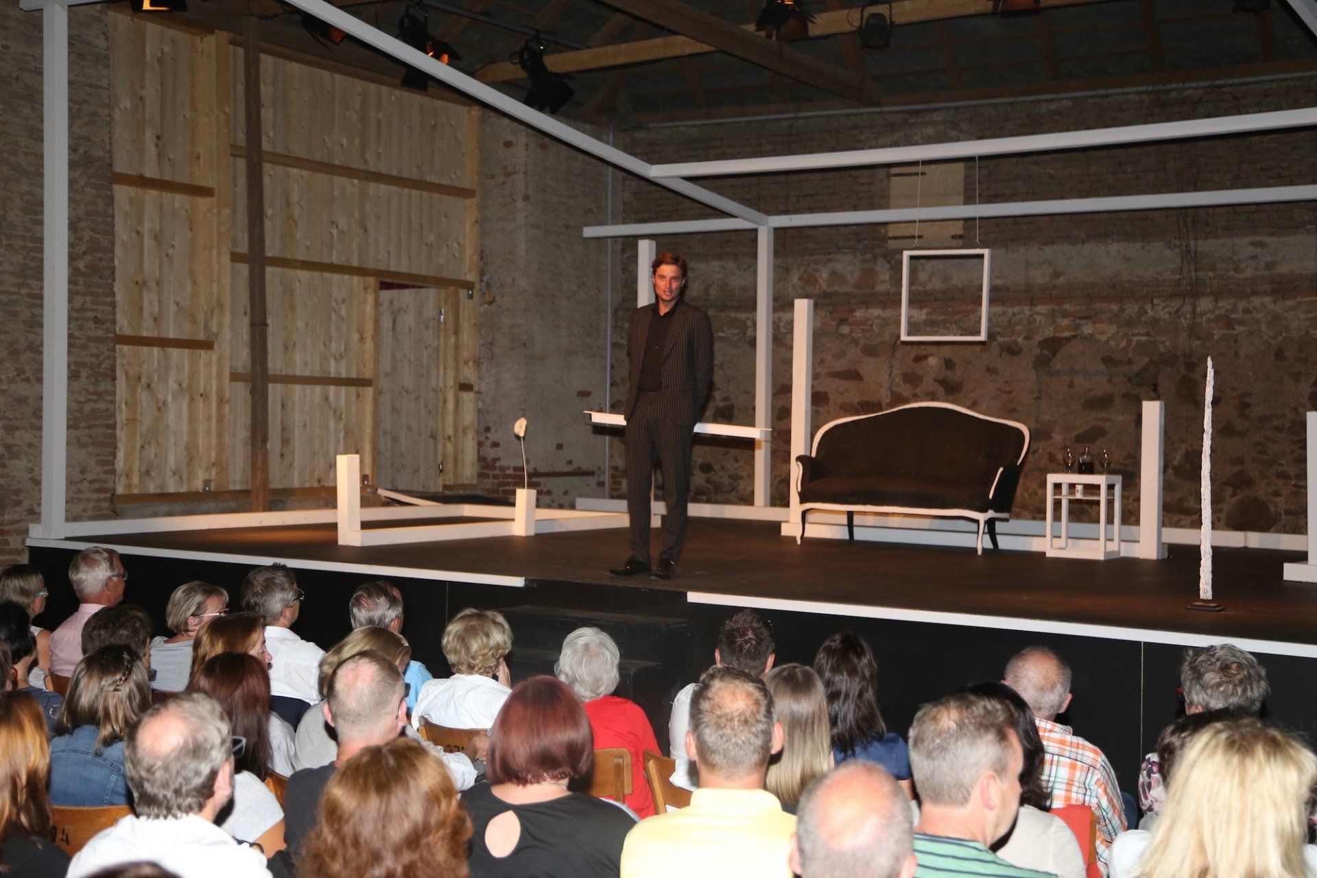 Ein Mann steht auf einer Bühne vor einer Menschenmenge